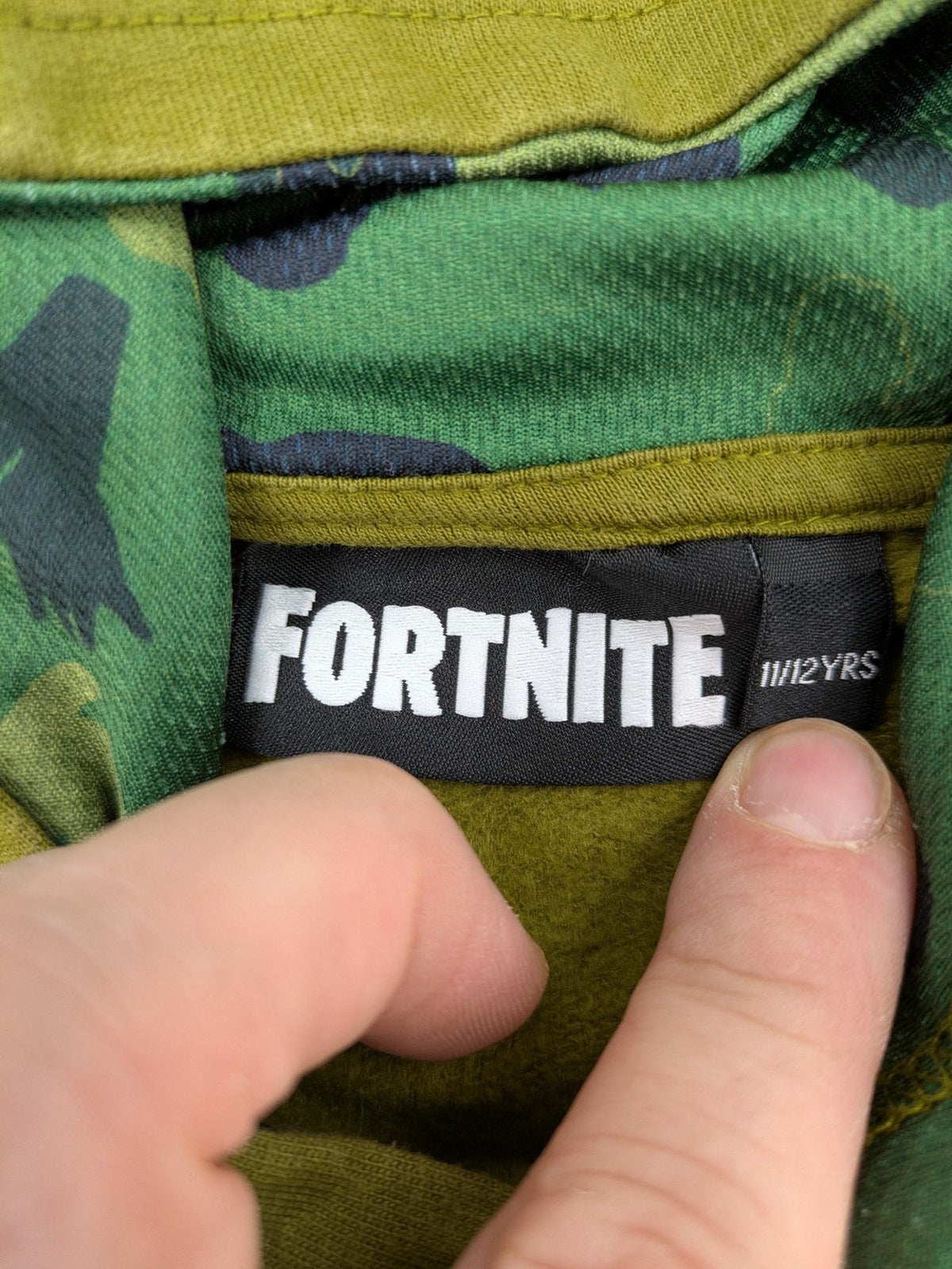 Fortnite green camo hoodie with black logo, contrasting hood, and logo taping on sleeves.