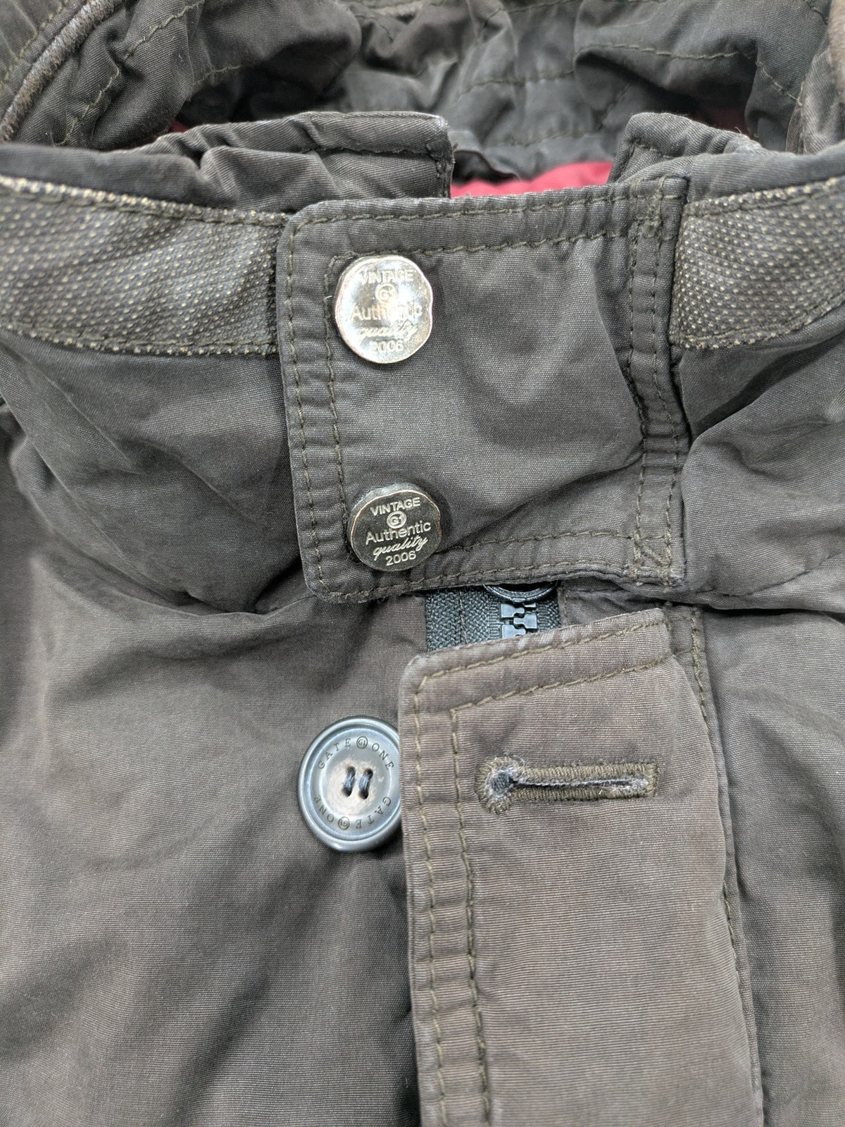 Gate One brown field jacket with plaid lining, multiple pockets, and zip-button closure.
