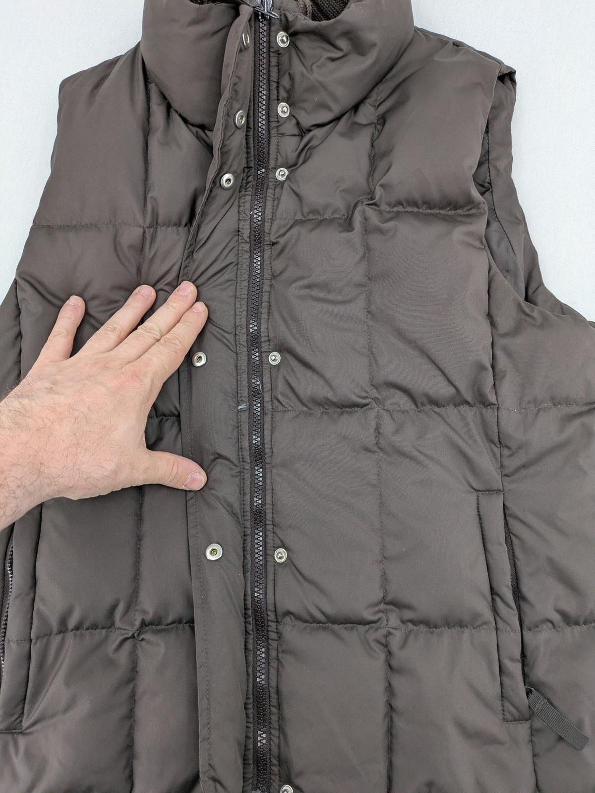 Esprit brown puffer vest with high ribbed collar and zip button closure.
