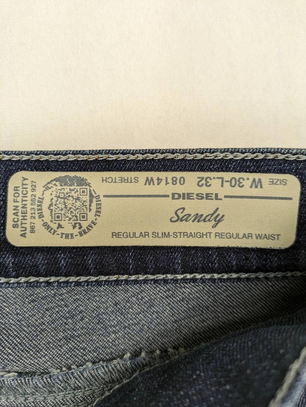 Diesel blue straight jeans with regular waist, dark wash, and stretch material.