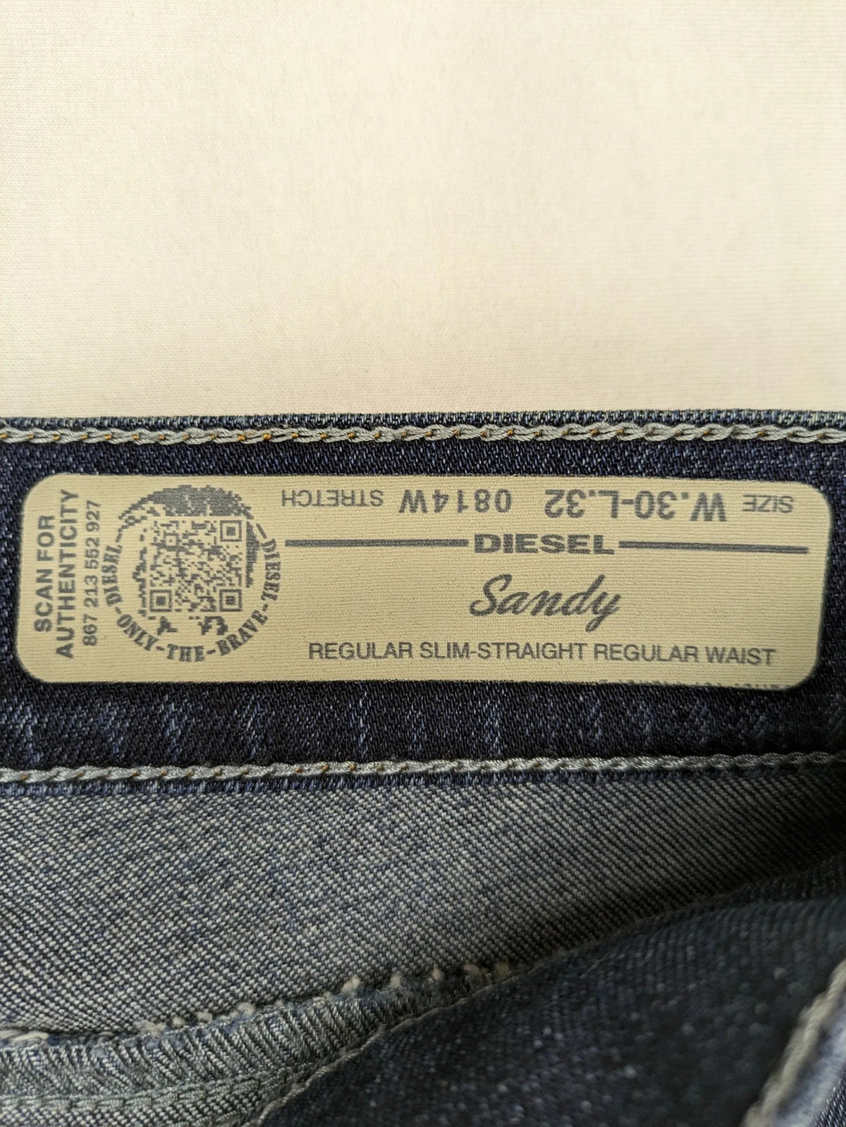 Diesel blue straight jeans with regular waist, dark wash, and stretch material.
