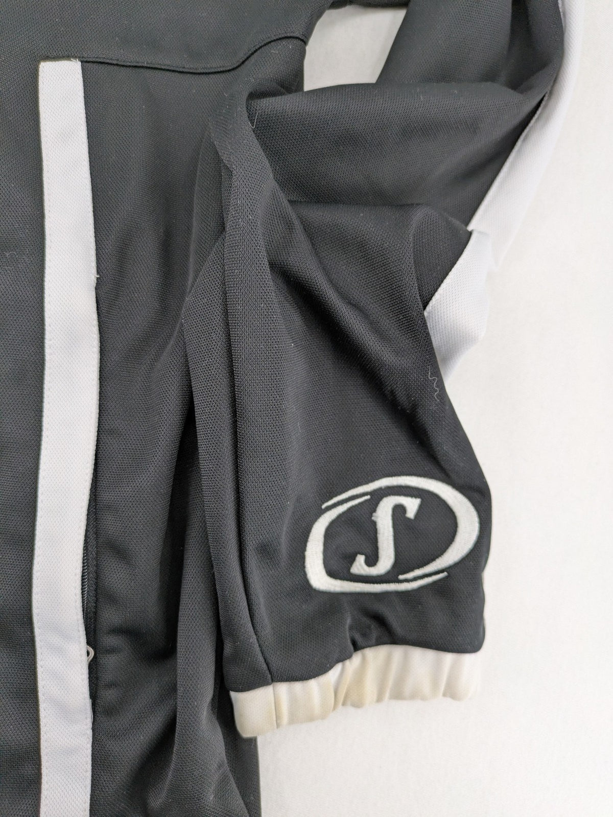 Spalding black training jacket with orange and white accents, Rasta Vechta logo, zip front.