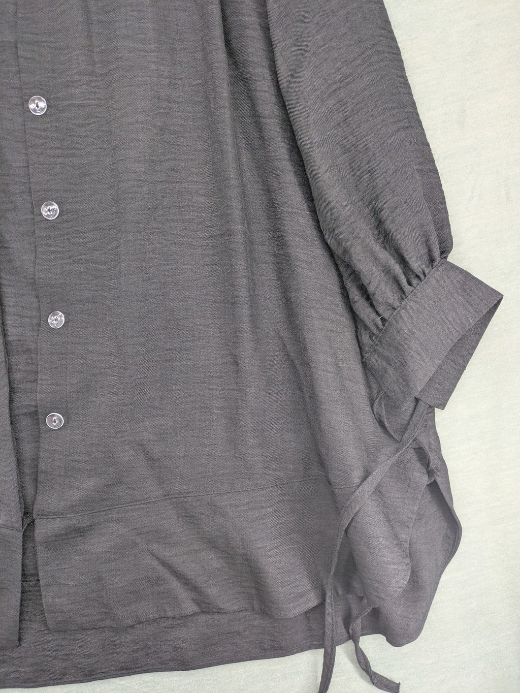 Damen grey turtle neck jumper with balloon sleeves and side ties, high-low hem.
