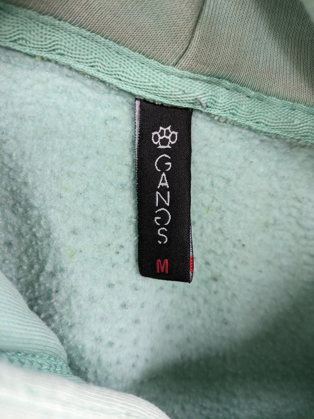 Tupac black and green zip-through hoodie with "Only God Can Judge Me" front print and angel wings graphic.