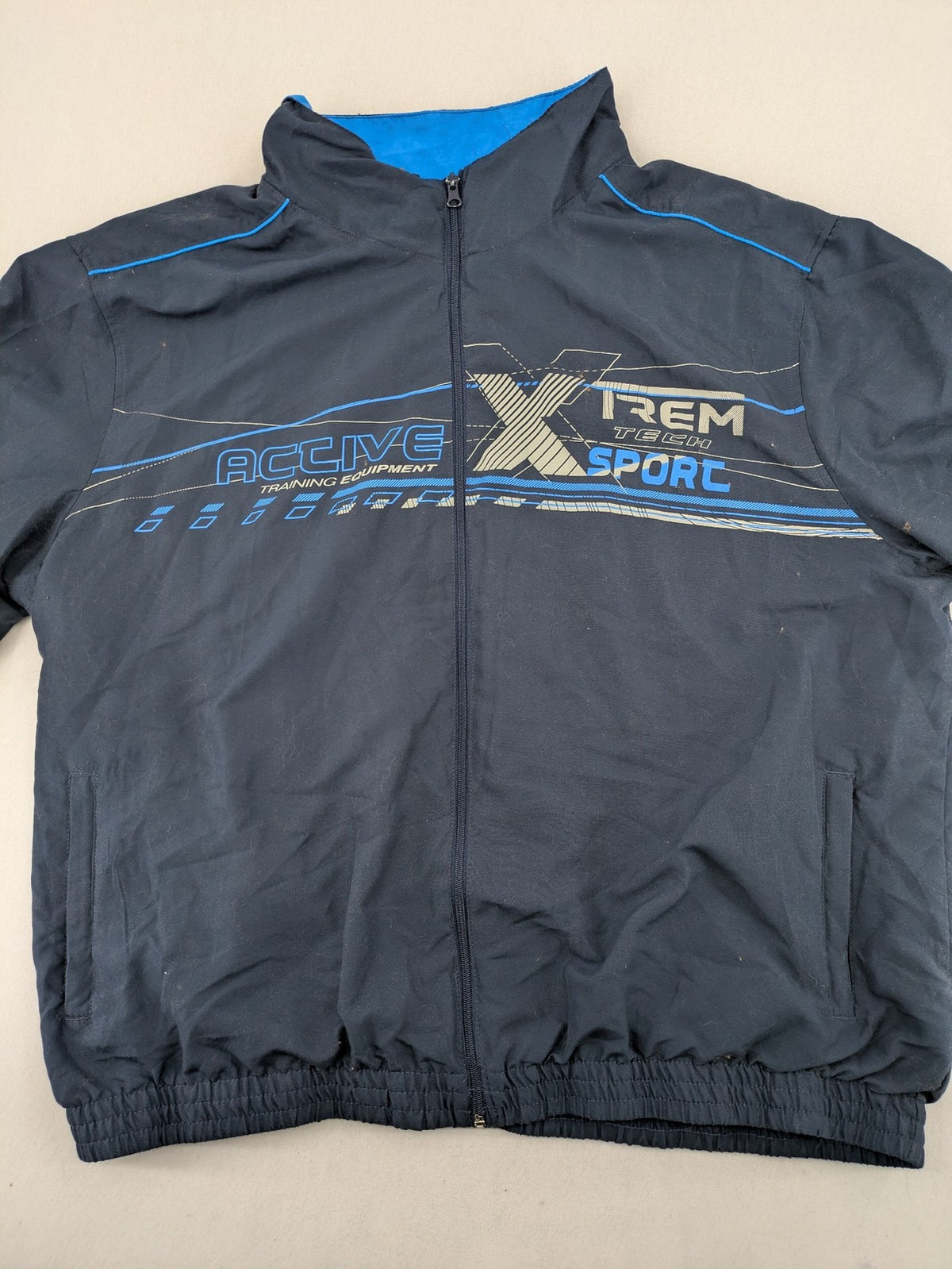 Atlas for Men blue windbreaker jacket with XTREM TECH SPORT graphic print and full zip.