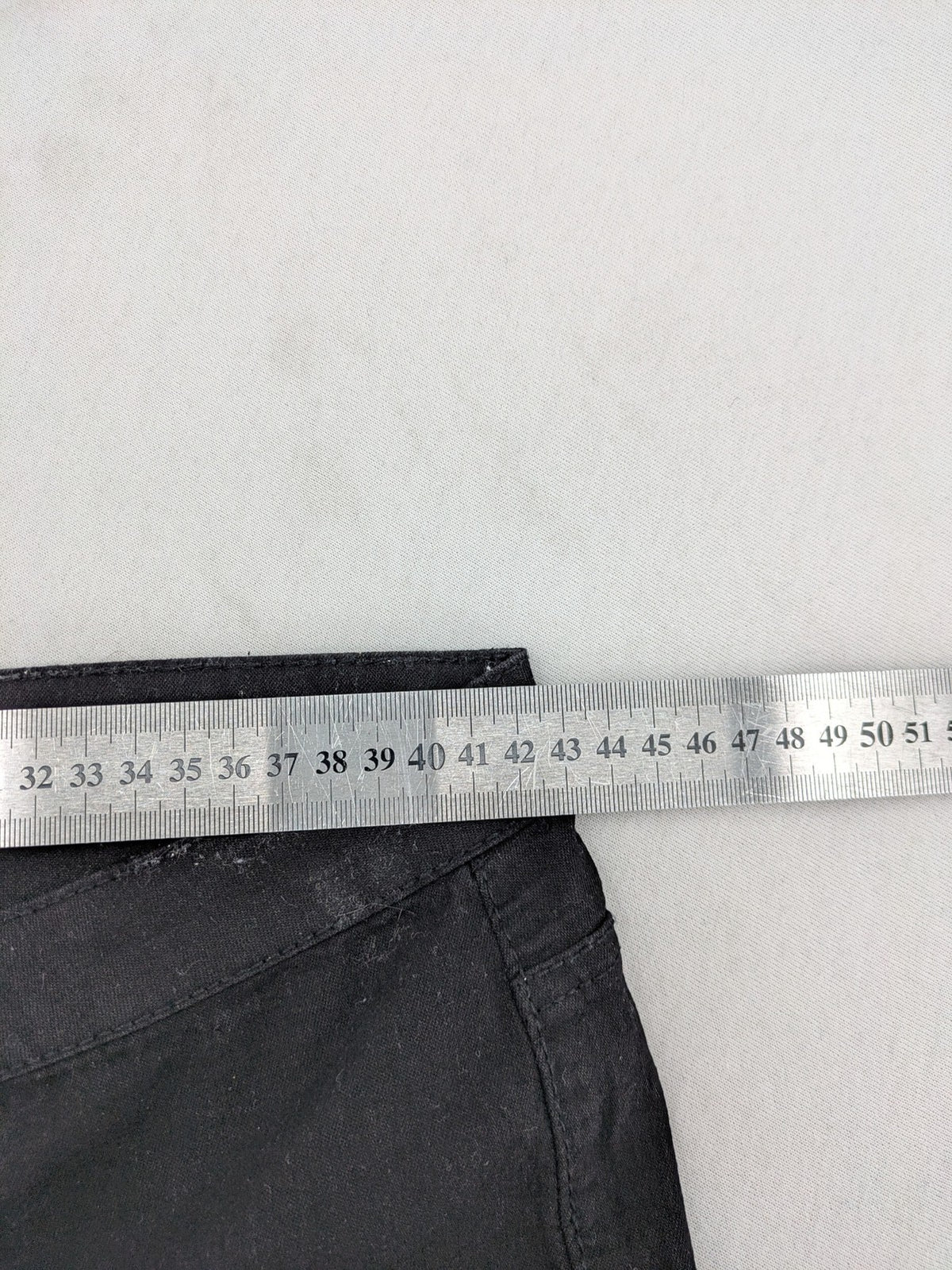 Denim & Co. black straight jeans with front button closure and back pockets.