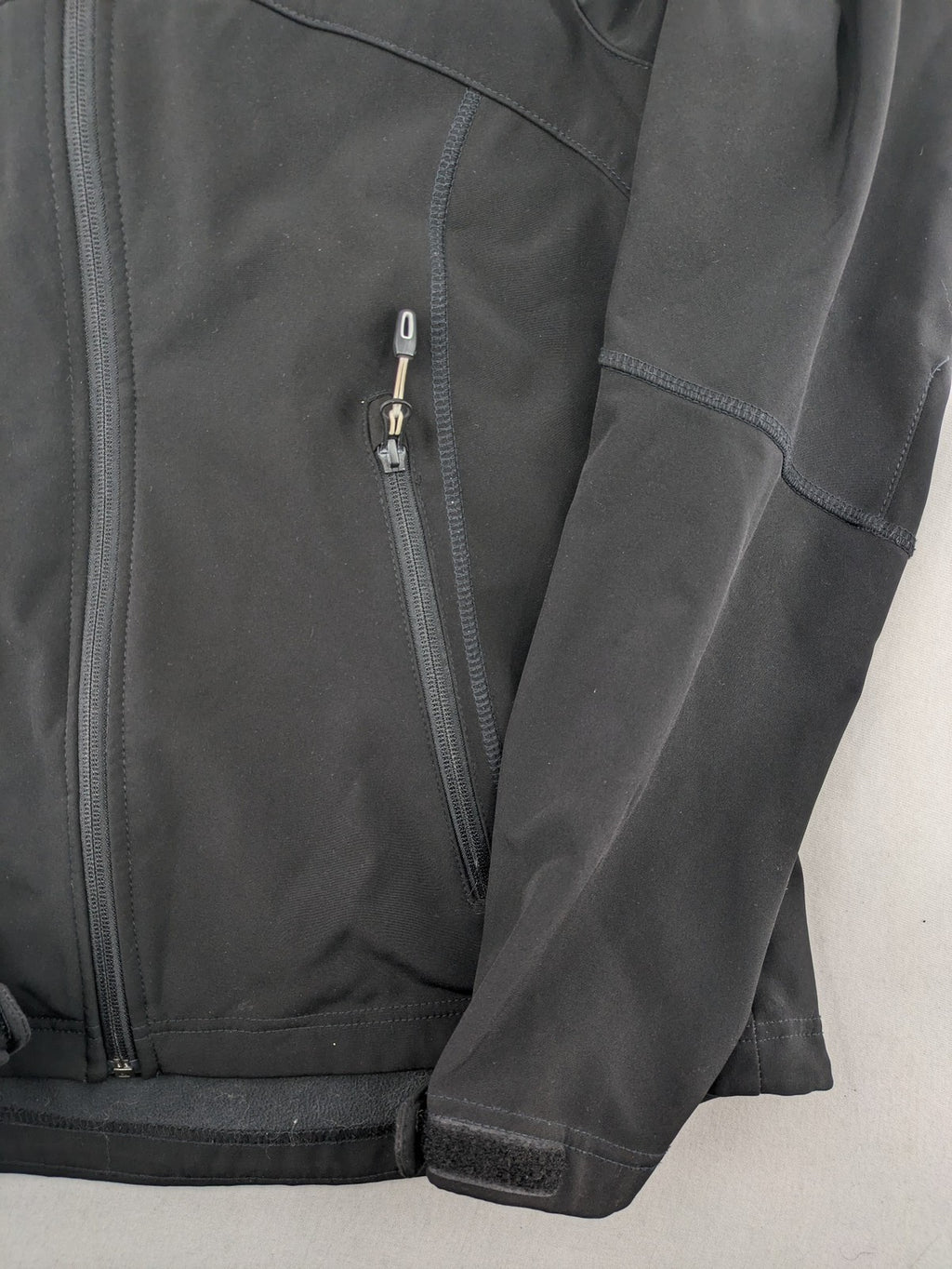 Icepeak black softshell jacket with fleece lining, adjustable hood, and zippered pockets.