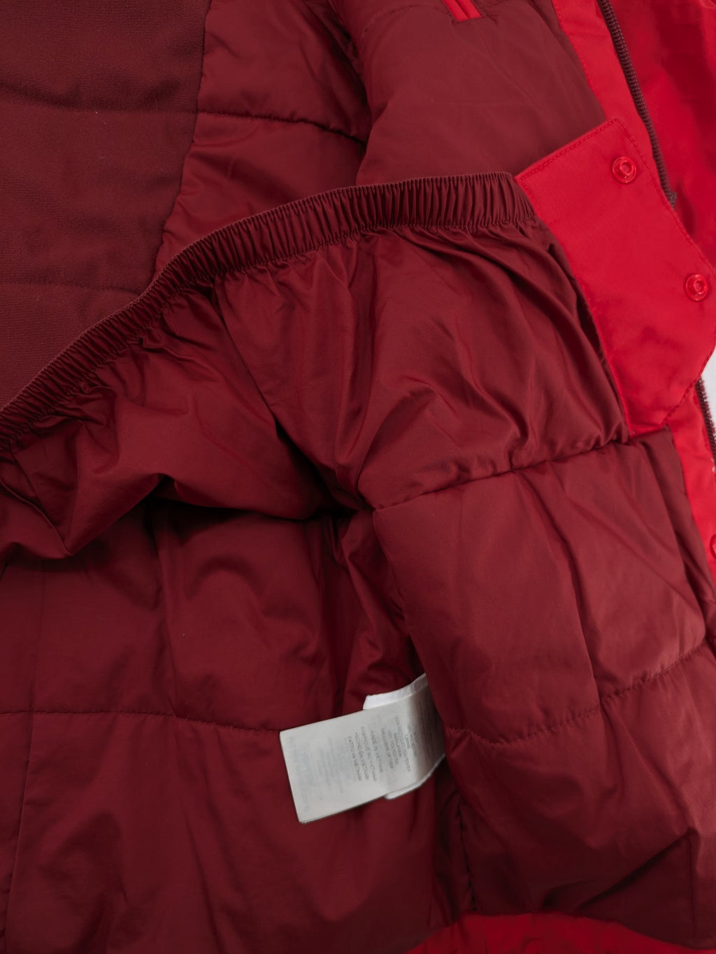Patagonia red winter coat with hood, zip closure, snow skirt, and ski pass pocket.