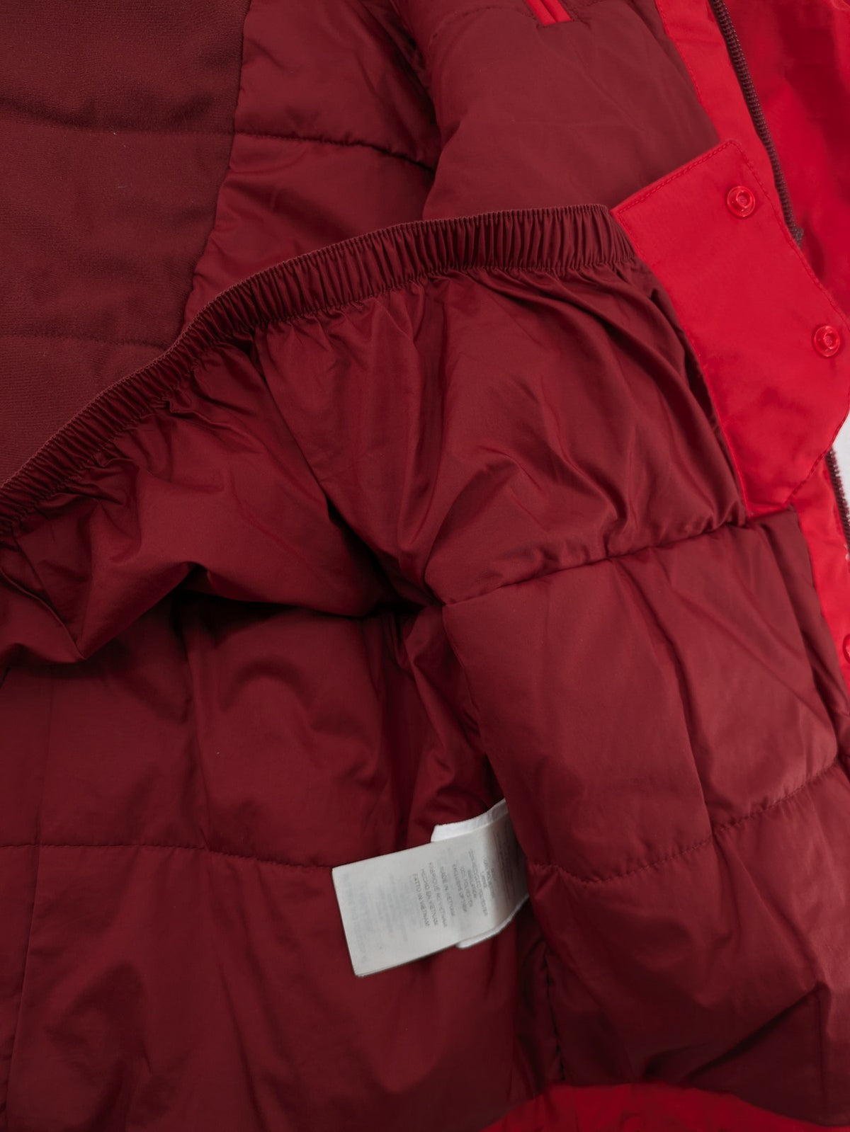Patagonia red winter coat with hood, zip closure, snow skirt, and ski pass pocket.