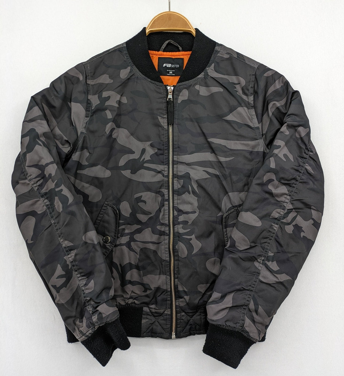 FB Sister orange bomber jacket with gray camouflage pattern and quilted lining.
