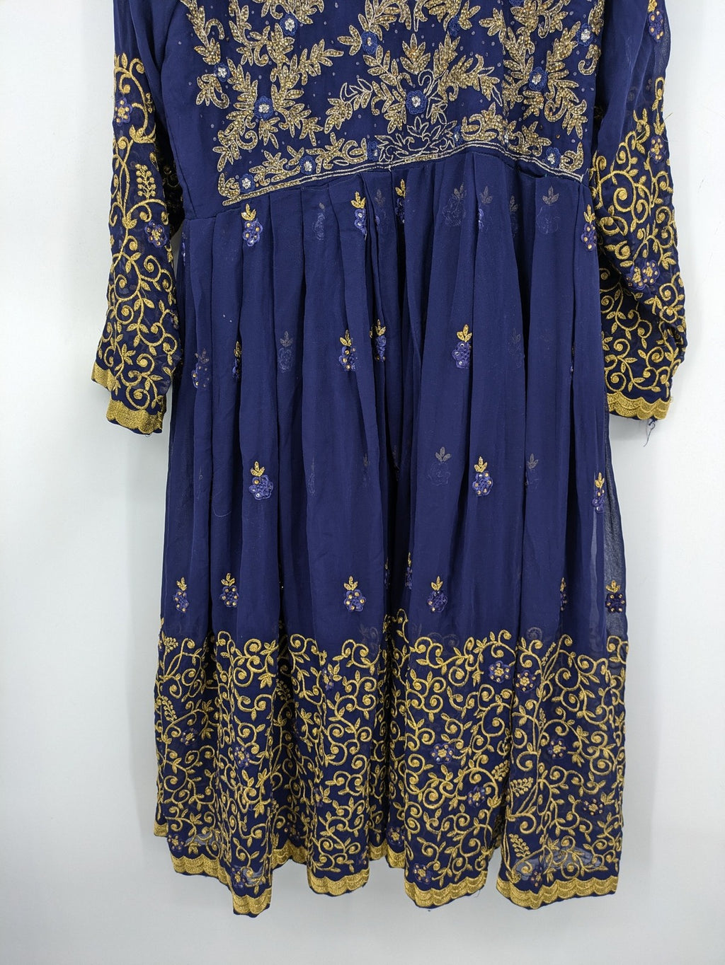 Bollywood bridal party dress gold with intricate blue embroidery and flowing Anarkali silhouette.