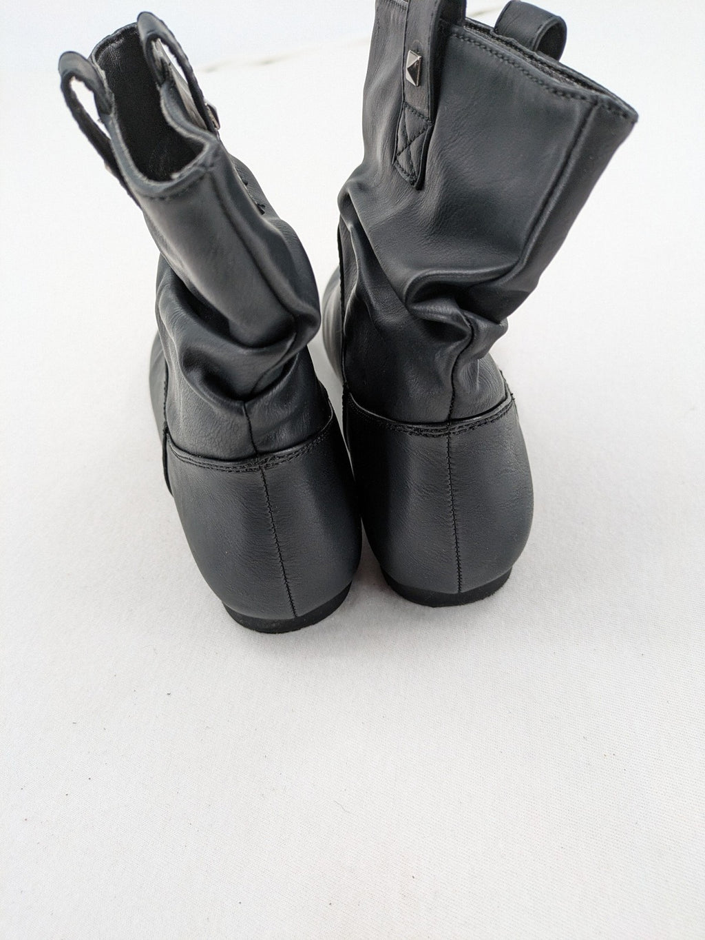 DAF black booties with decorative strap and studded details, made of faux leather.