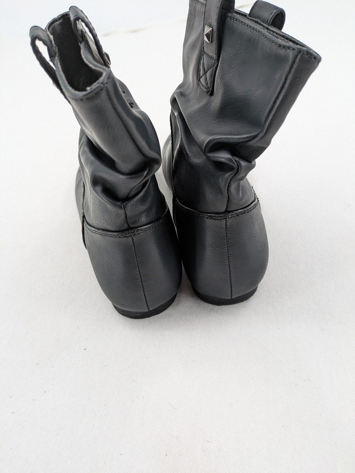 DAF black booties with decorative strap and studded details, made of faux leather.