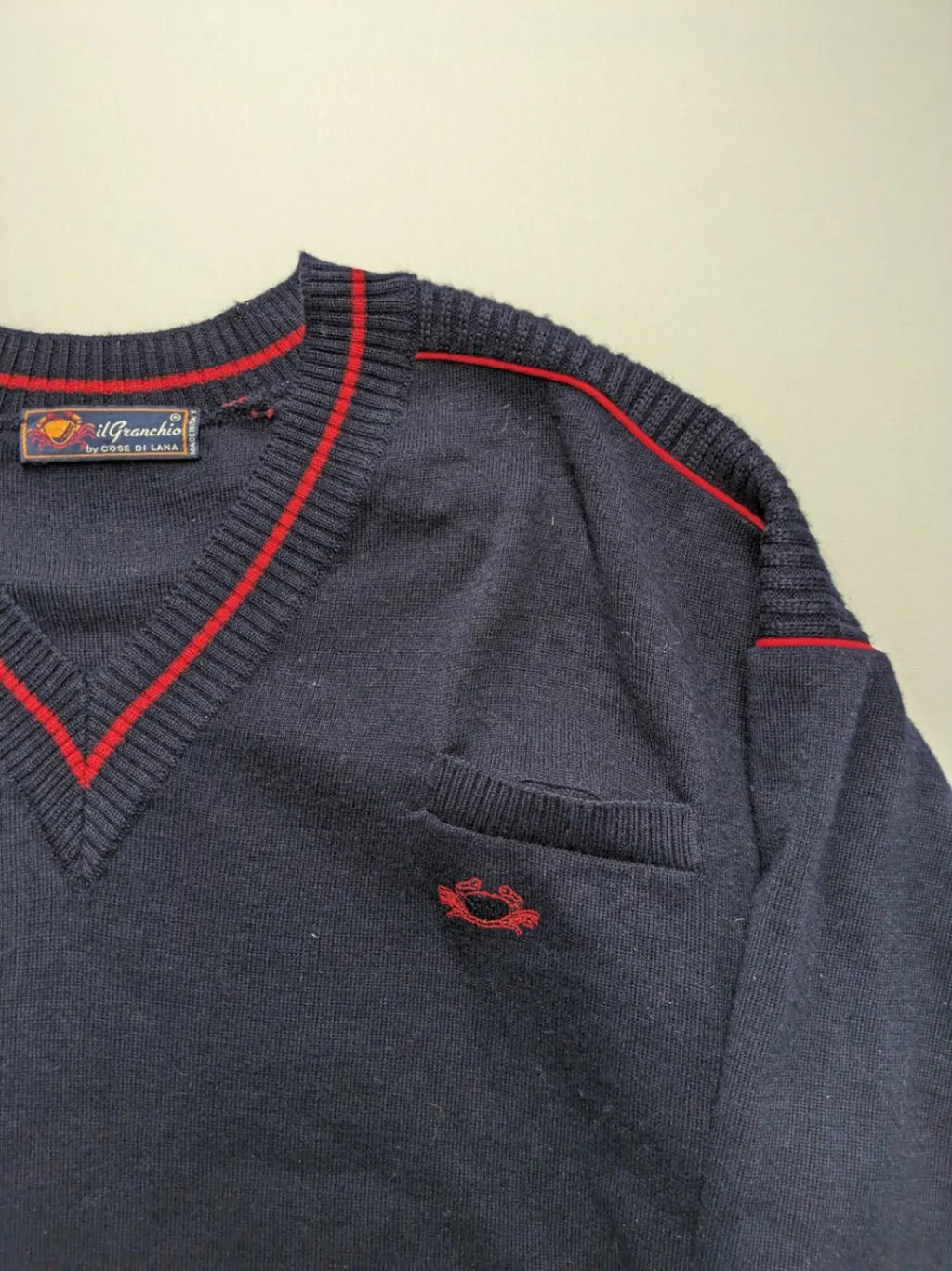 Il Granchio grey turtle neck jumper with red accents and embroidered crab logo.