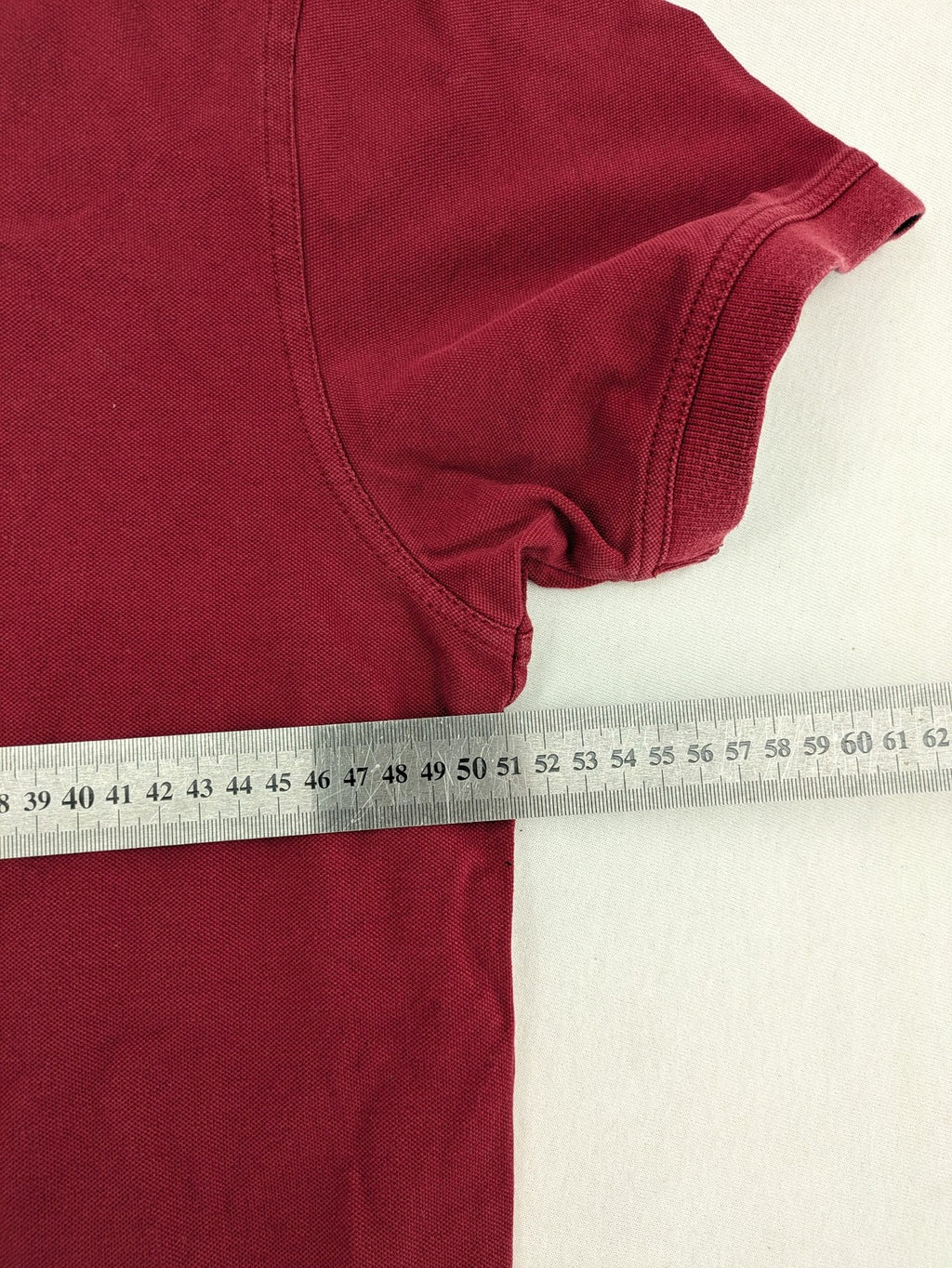 GANT burgundy polo shirt with embroidered shield logo and contrasting navy collar details.