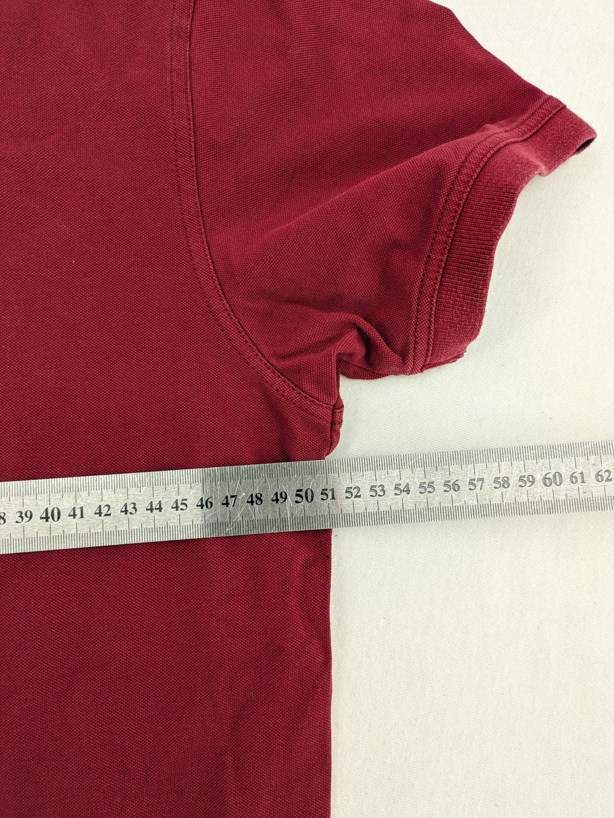 GANT burgundy polo shirt with embroidered shield logo and contrasting navy collar details.