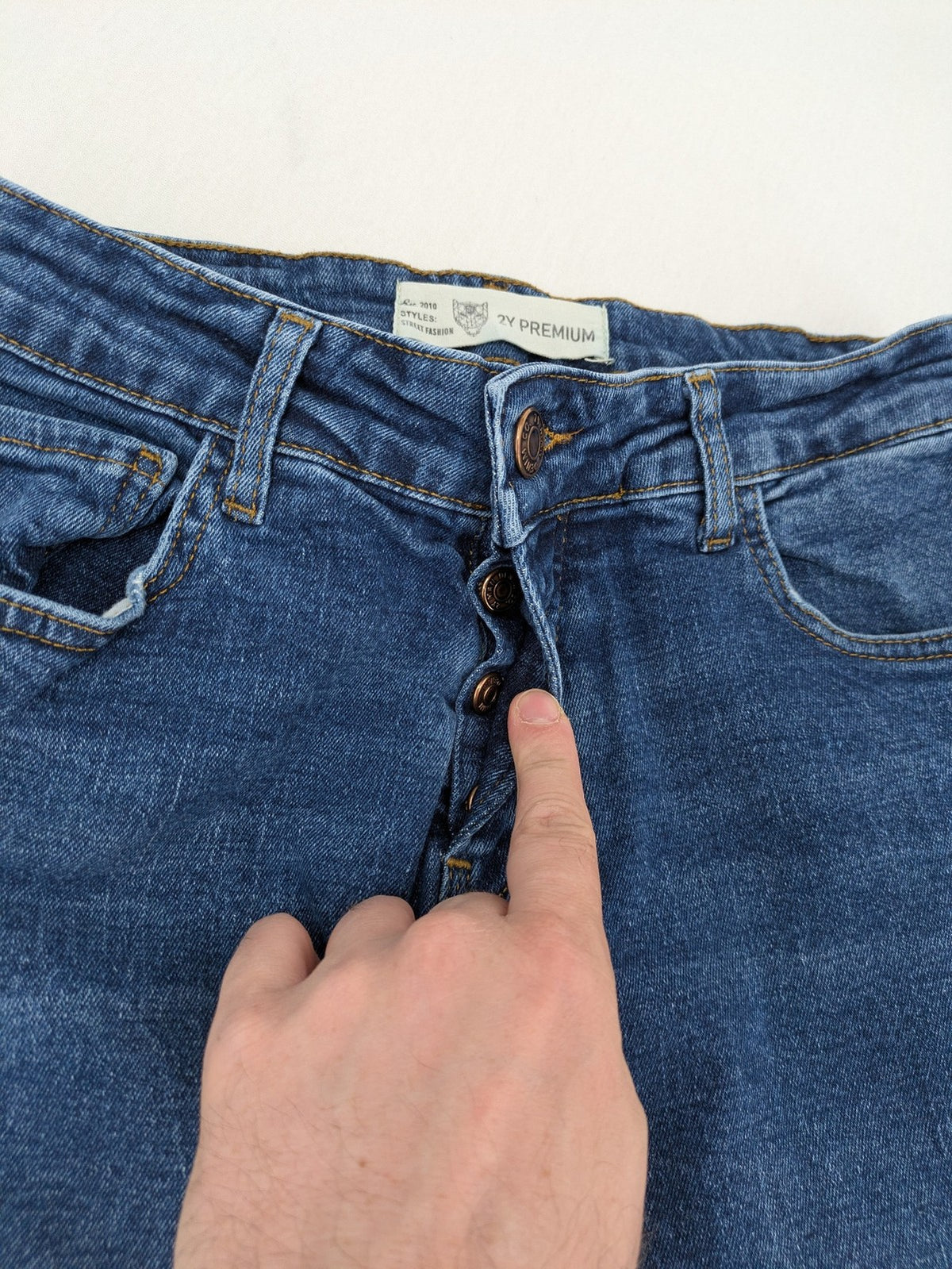 2Y Premium blue skinny jeans with distressed details and classic button fly.