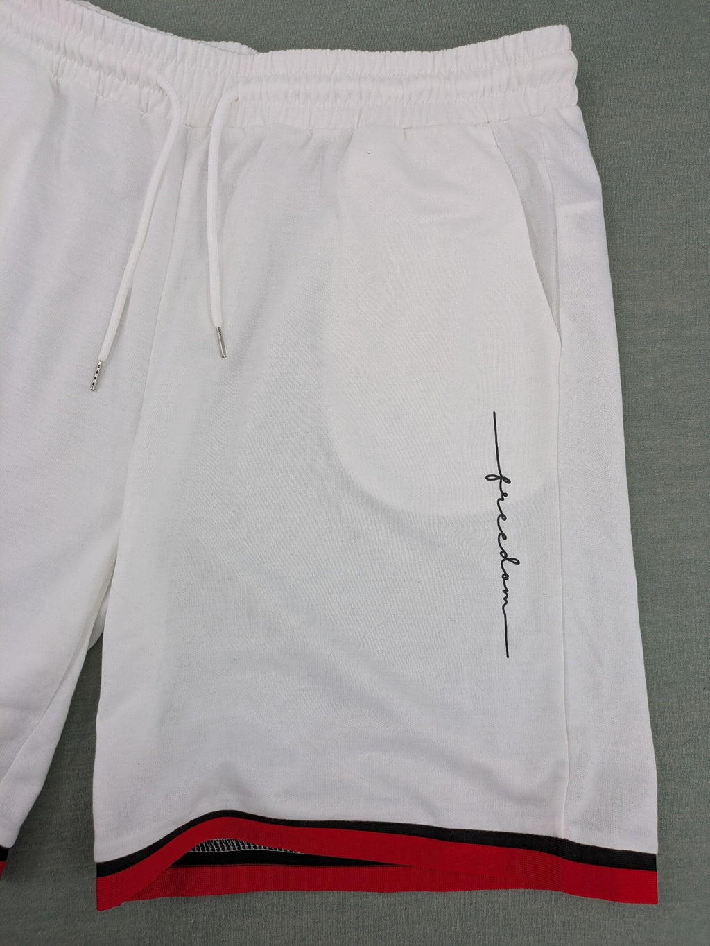 Manfinity black and white outfit set with red accents and "Freedom" graphic print.