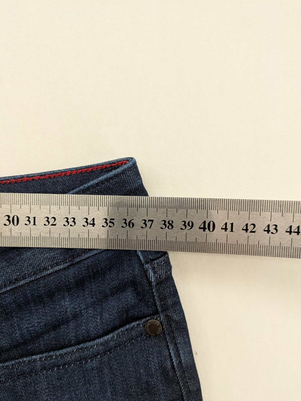 Tommy Hilfiger blue straight jeans with iconic logo and dark wash denim finish.