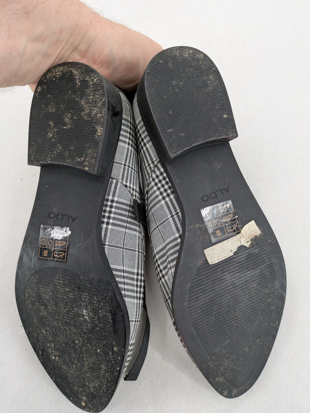 ALDO black and white checkered loafers with decorative bow detail and pointed toe.