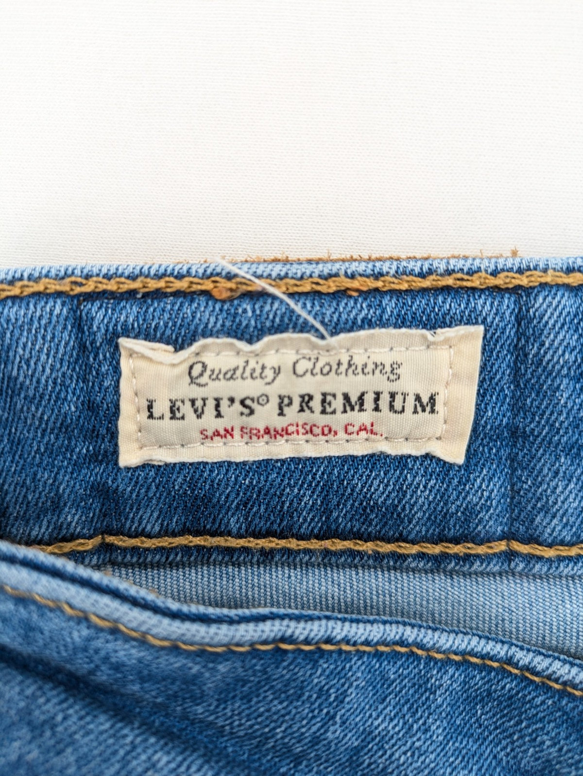Levi's blue skinny jeans with raw hem, classic five-pocket design, and zip fly.