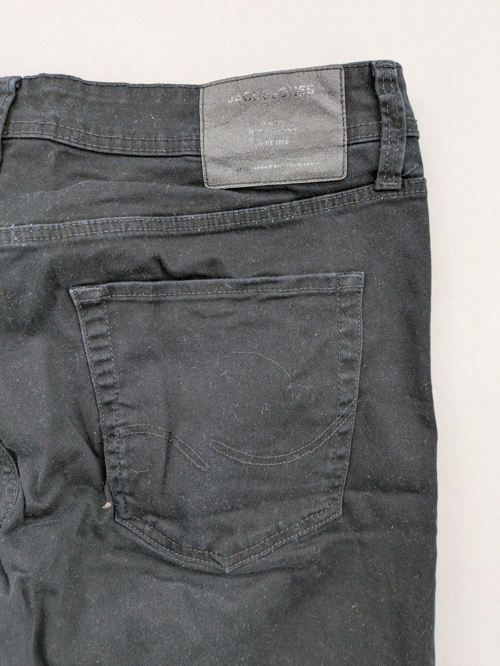 Jack & Jones black slim fit jeans with logo patch and cotton-stretch blend.