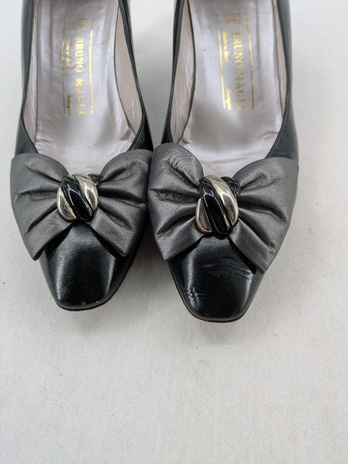 Bruno Magli black high heels leather with grey bow detail and classic silhouette.
