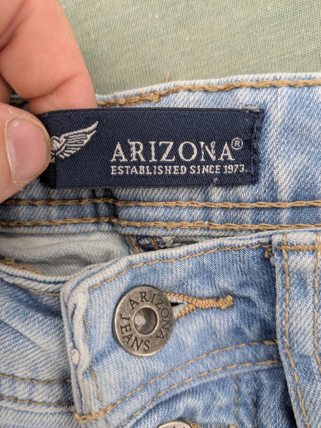 Arizona blue flare jeans with acid wash, button fly, and stretch denim material.