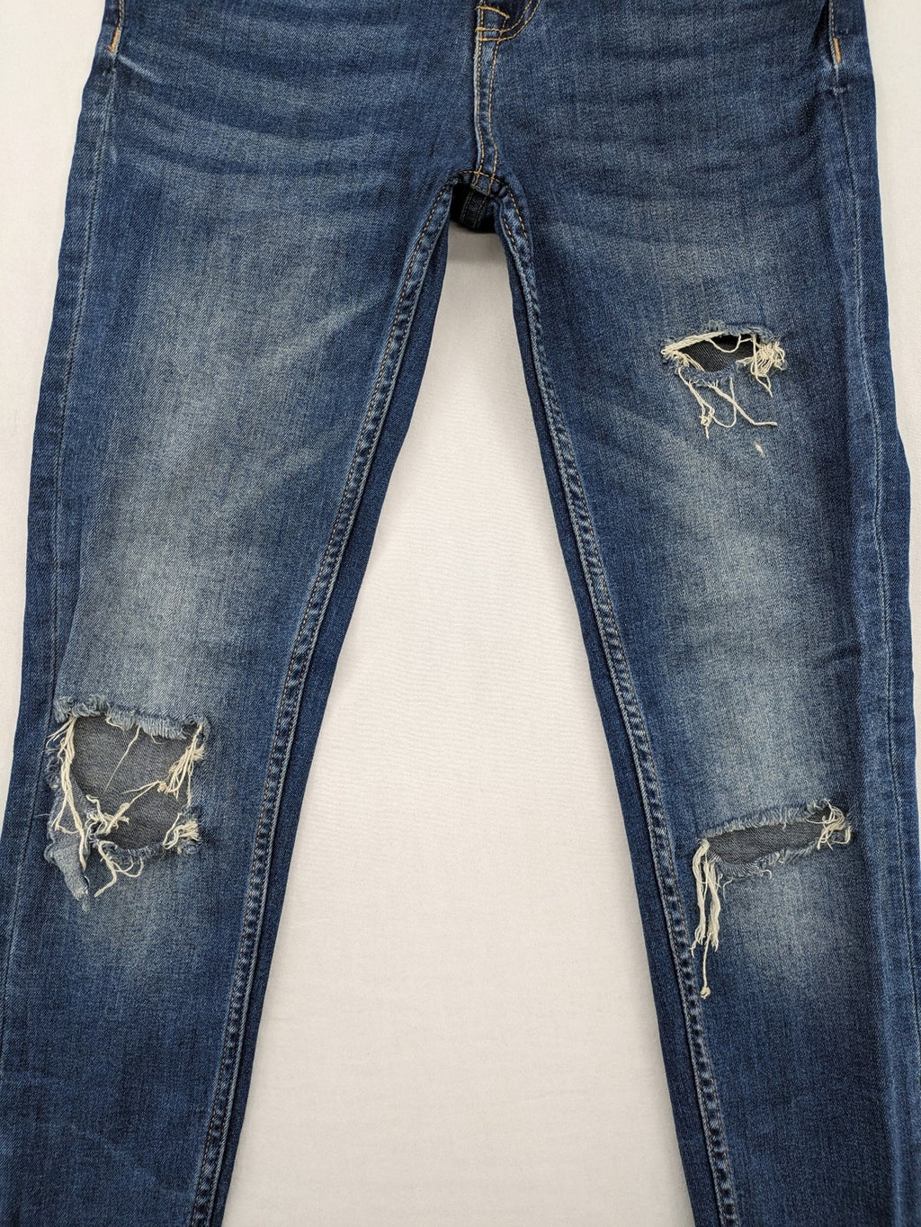 Zara Basic blue skinny jeans with destroyed knee details and frayed hem.