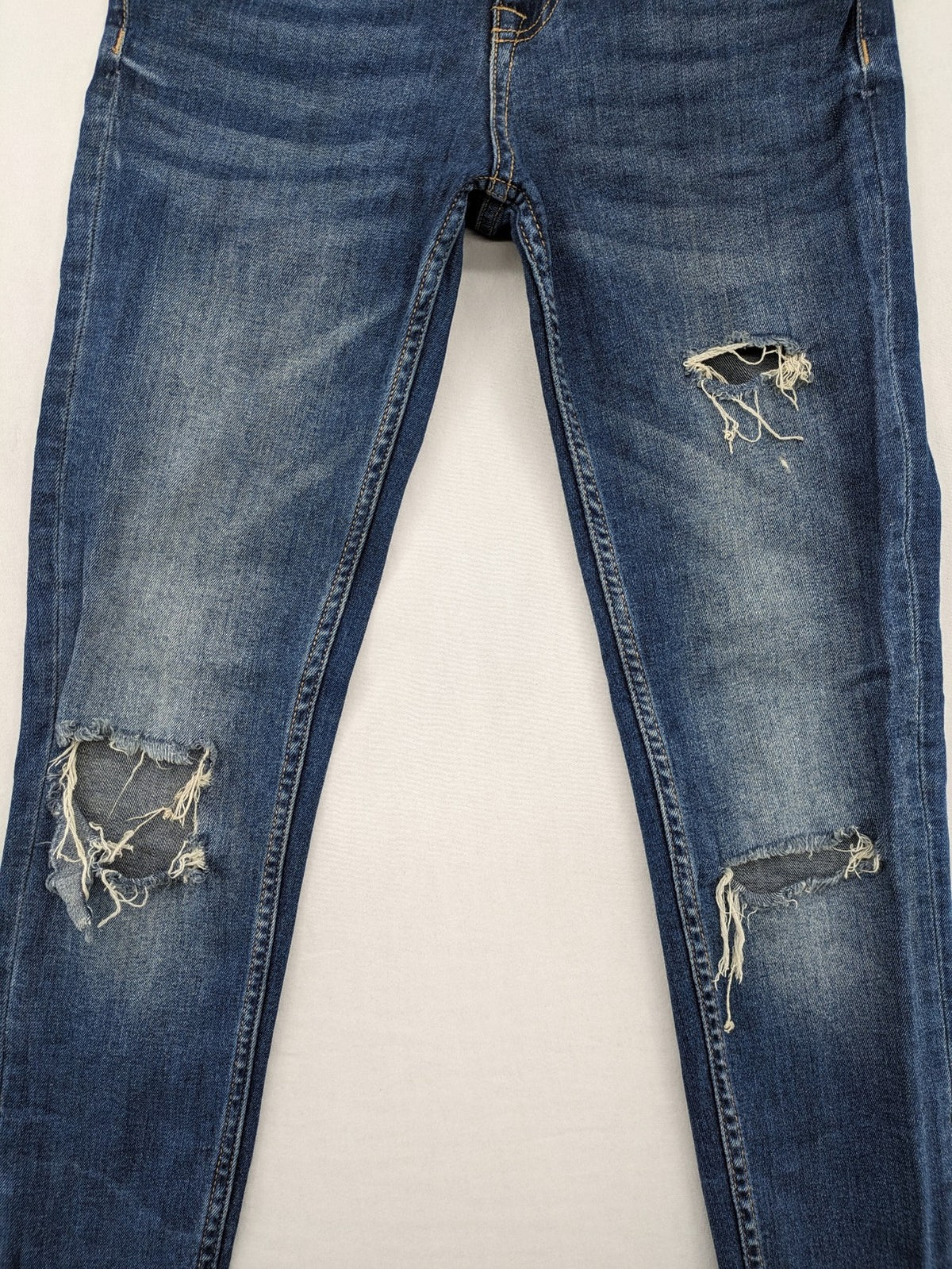 Zara Basic blue skinny jeans with destroyed knee details and frayed hem.