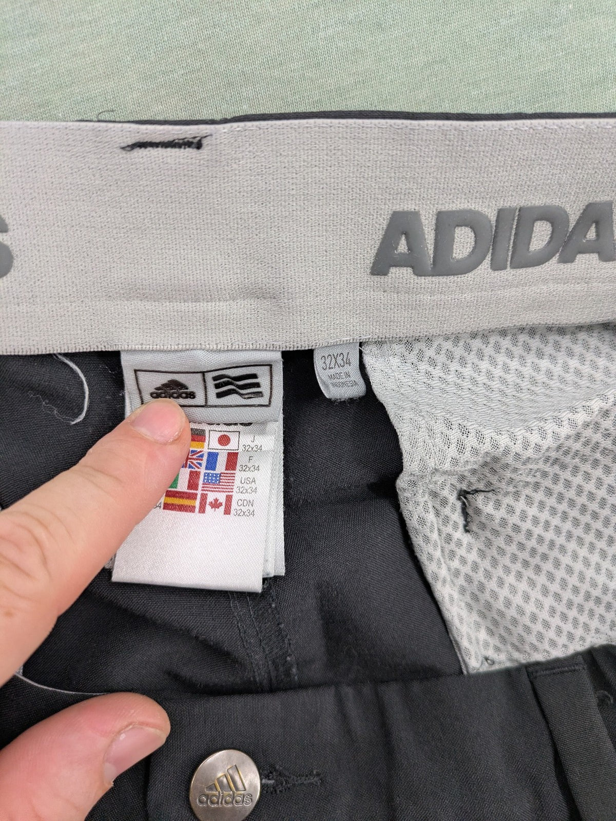 Adidas grey pants with 3-stripe logo, flat-front design, made from performance material.