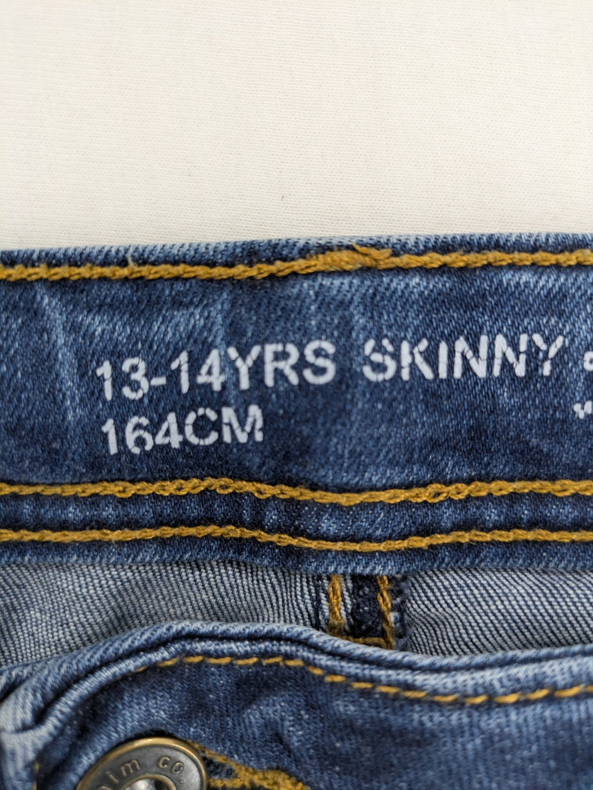 Denim & Co. blue skinny jeans with distressed ripped details and adjustable waistband.