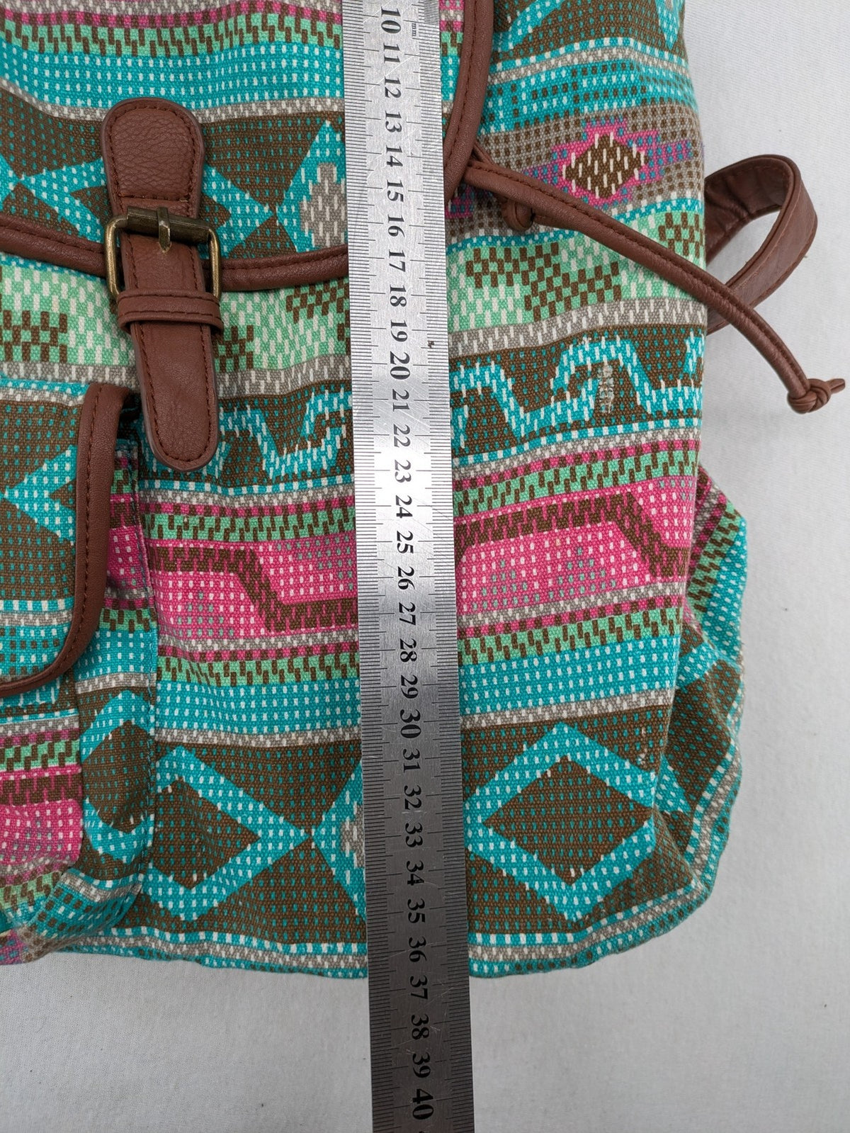 Boho multi backpack with vibrant Aztec tribal print and brown faux leather accents.