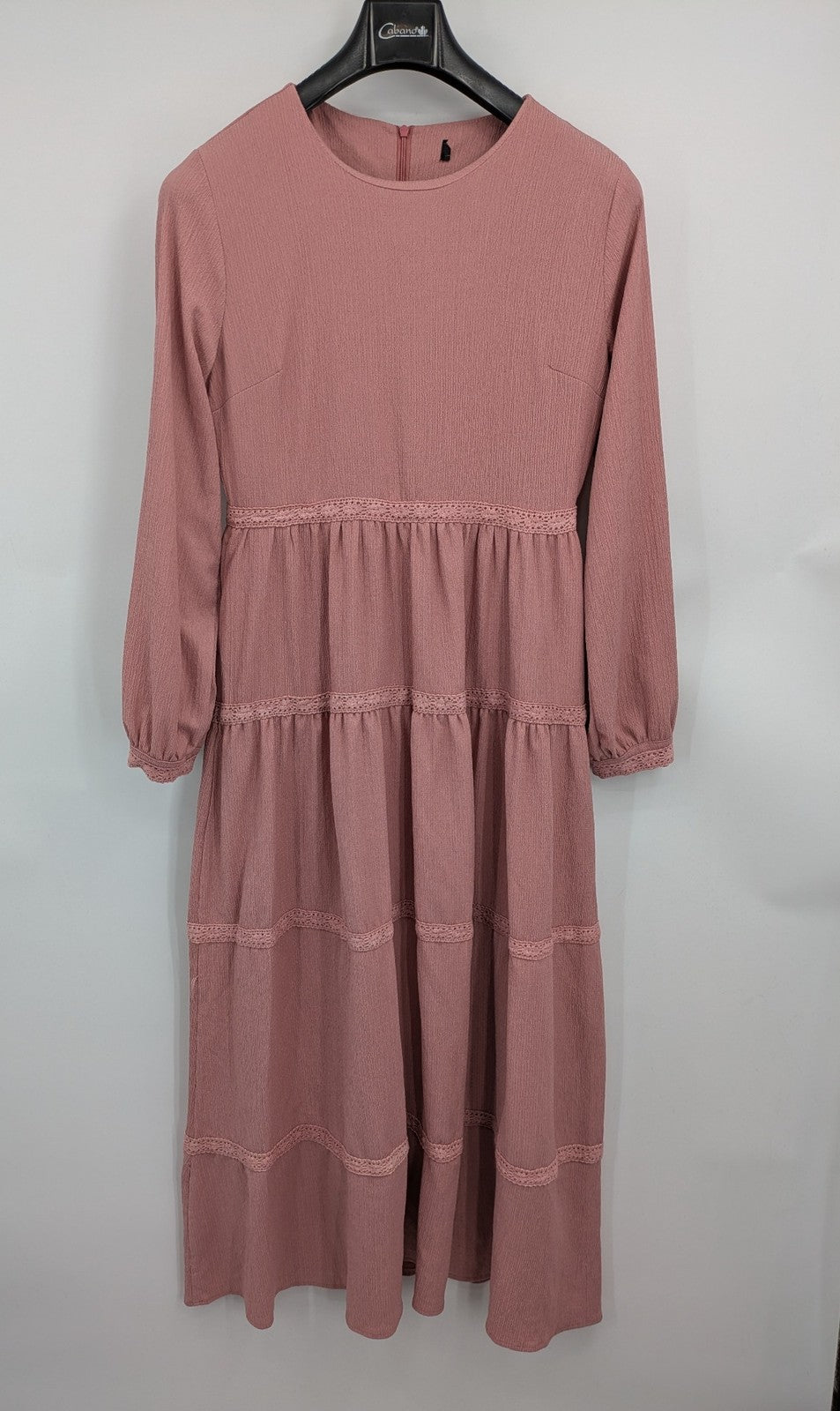 Moda pink bridal party dress with lace inserts, long sleeves, and tiered design.