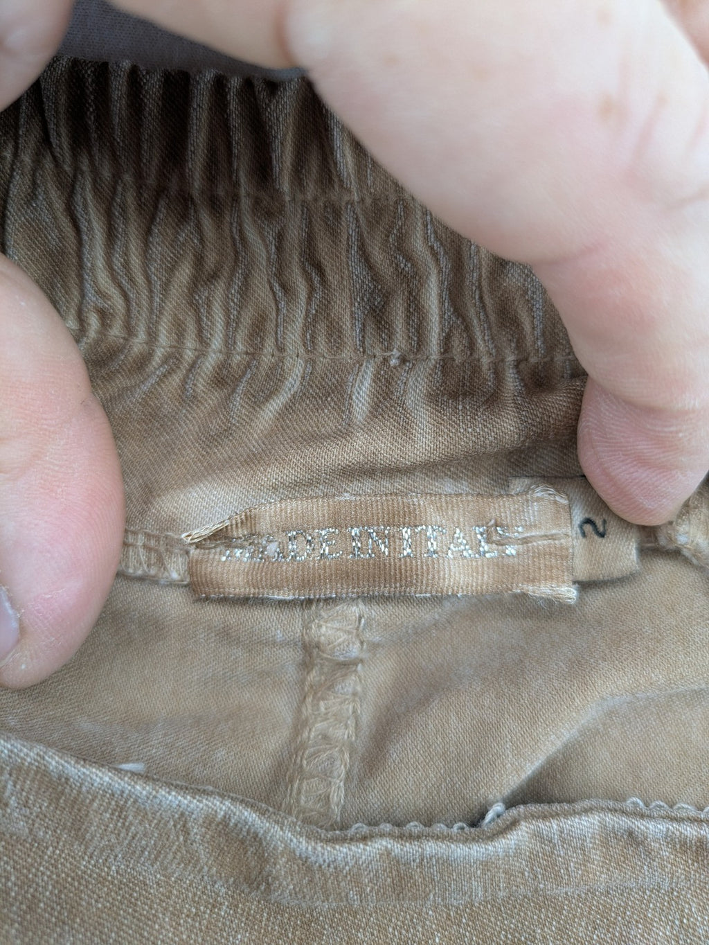 TREDY brown high-waist pants with decorative button placket and elastic waistband, soft knit texture.