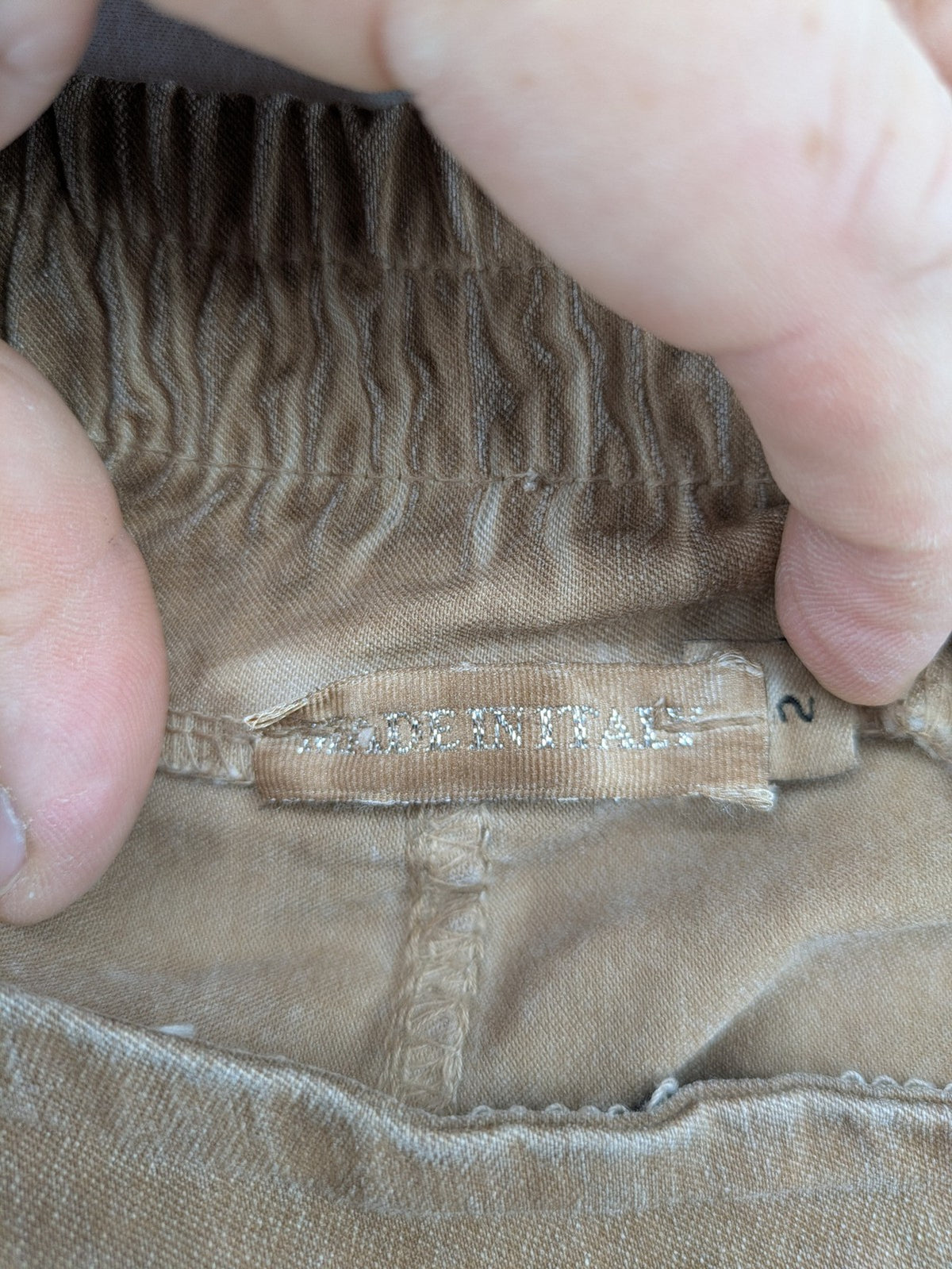 TREDY brown high-waist pants with decorative button placket and elastic waistband, soft knit texture.