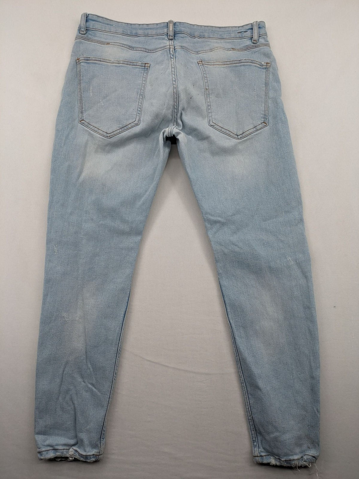 Zara blue straight jeans with distressed knees and classic button fly.