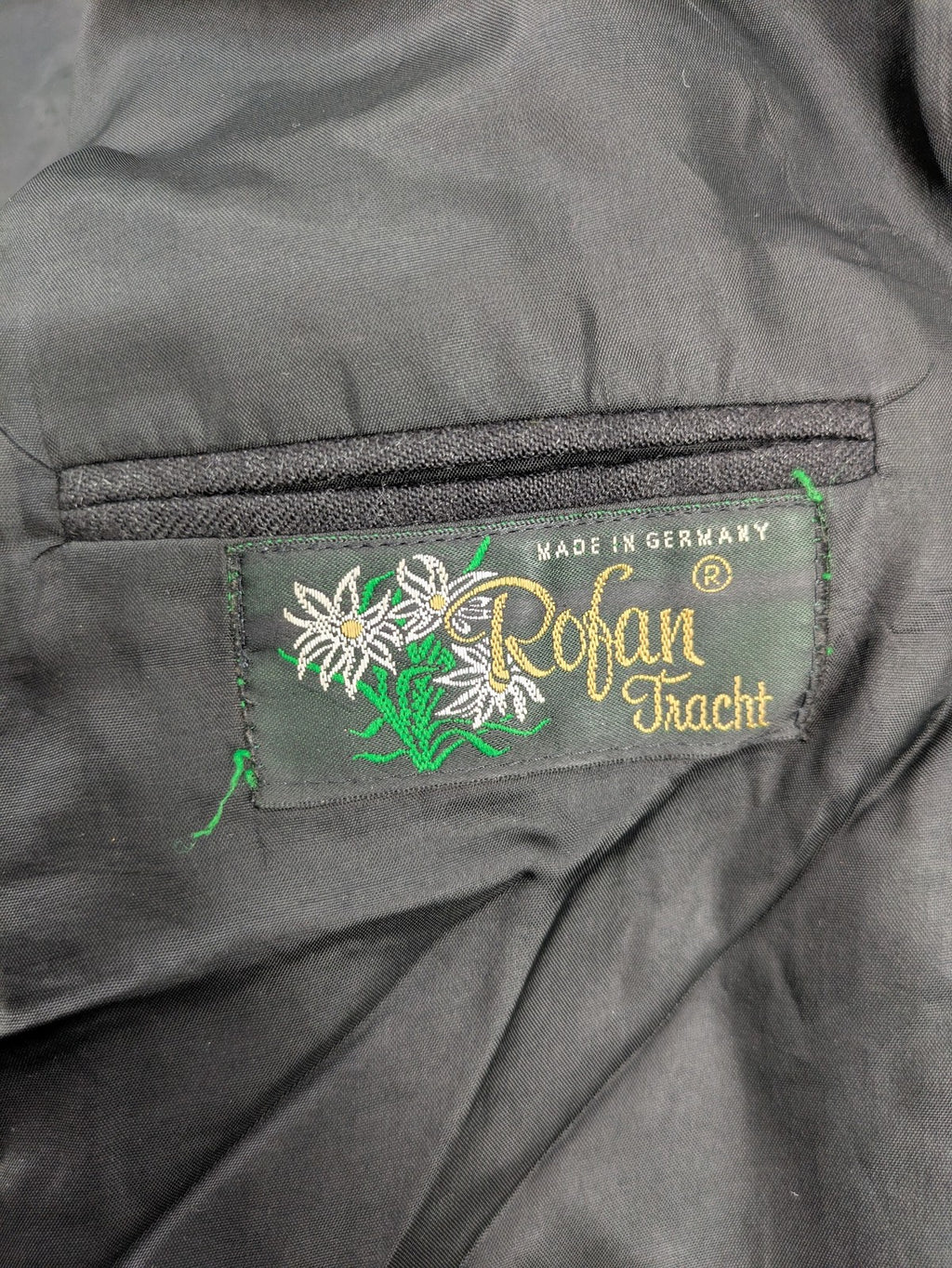 Rofan Tracht grey jacket with green stand-up collar and pockets, made from 100% wool.