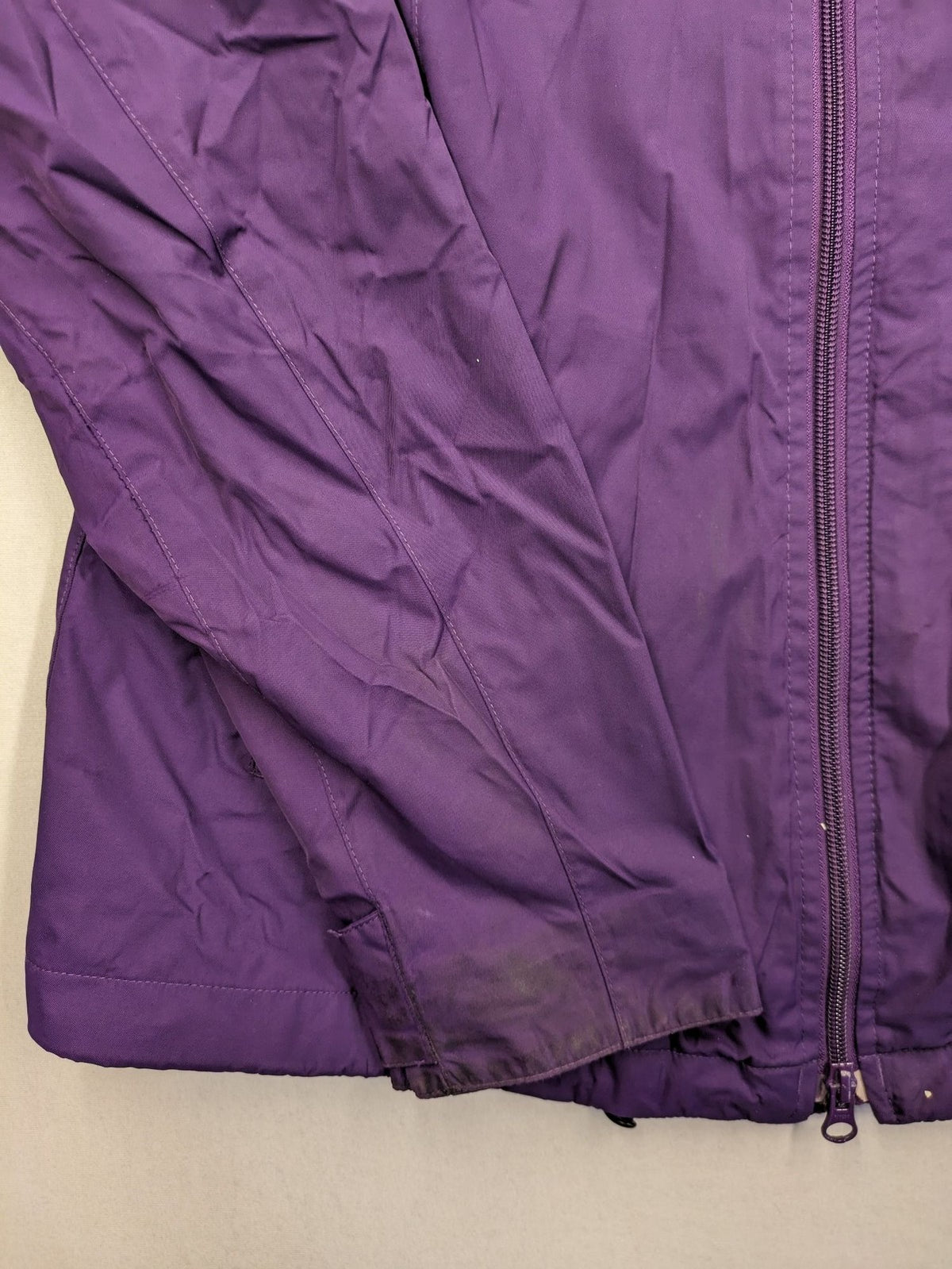 Jack Wolfskin purple outdoor jacket with adjustable hood and full zip, lightweight Stormlock material.