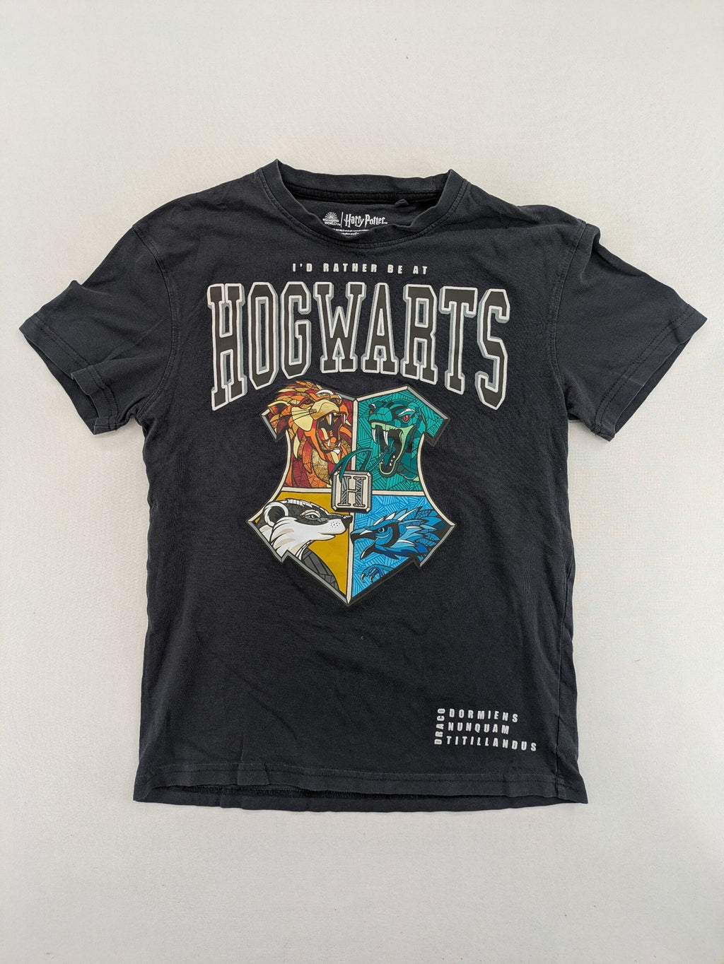 Harry Potter blue t-shirt featuring colorful Hogwarts crest and "I'd Rather Be At Hogwarts" slogan.
