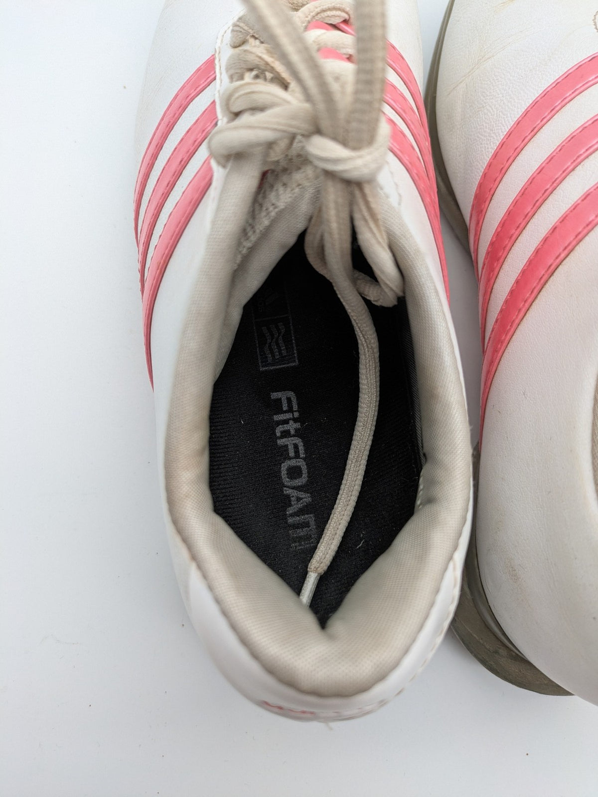 Adidas white golf shoes with pink stripes, Thintech and TRAXION technology, stylish design.