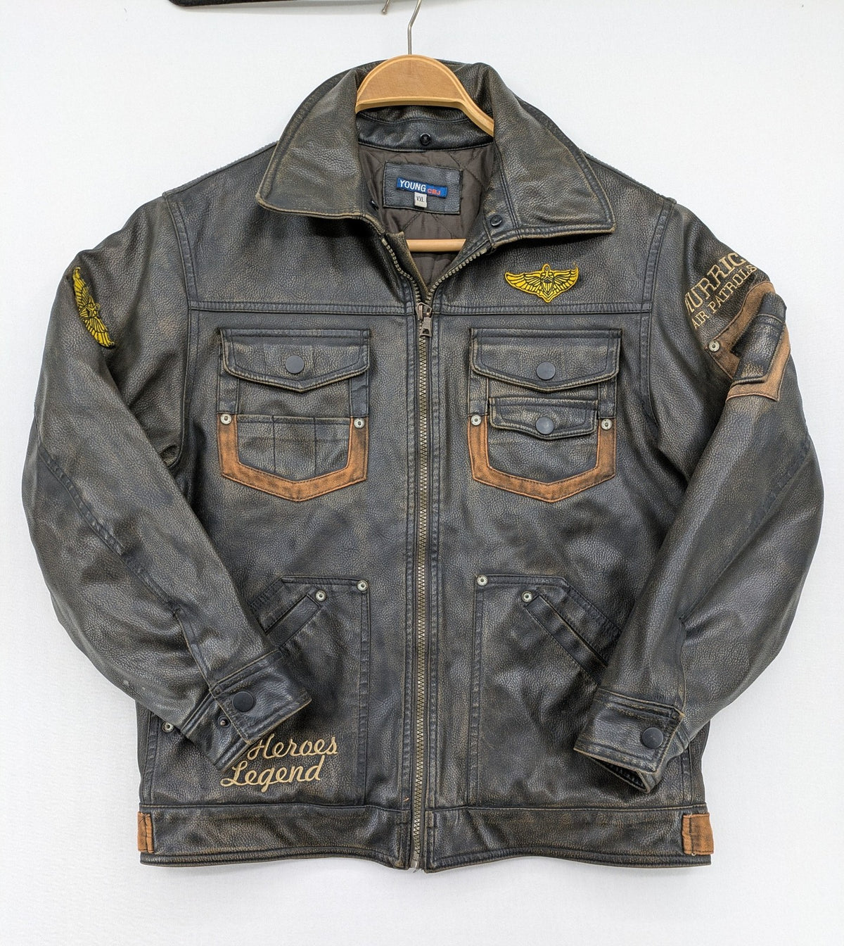 Junge brown bomber jacket with vintage patches and embroidered details in faux leather.