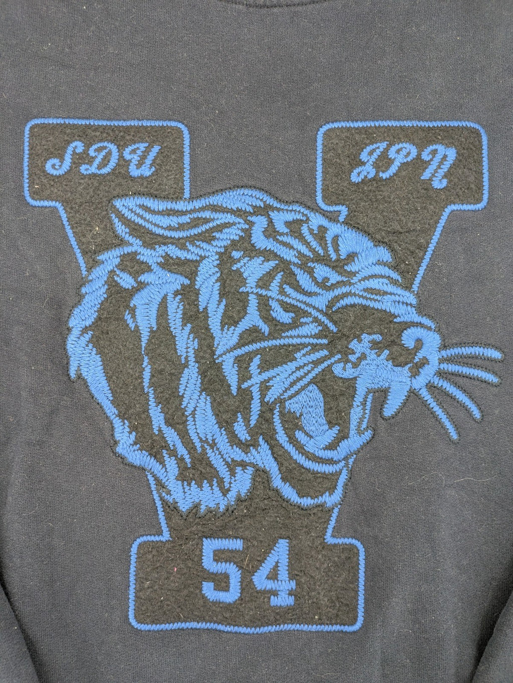 Superdry navy sweatshirt with embroidered tiger graphic and "JPN 54" chenille detail.