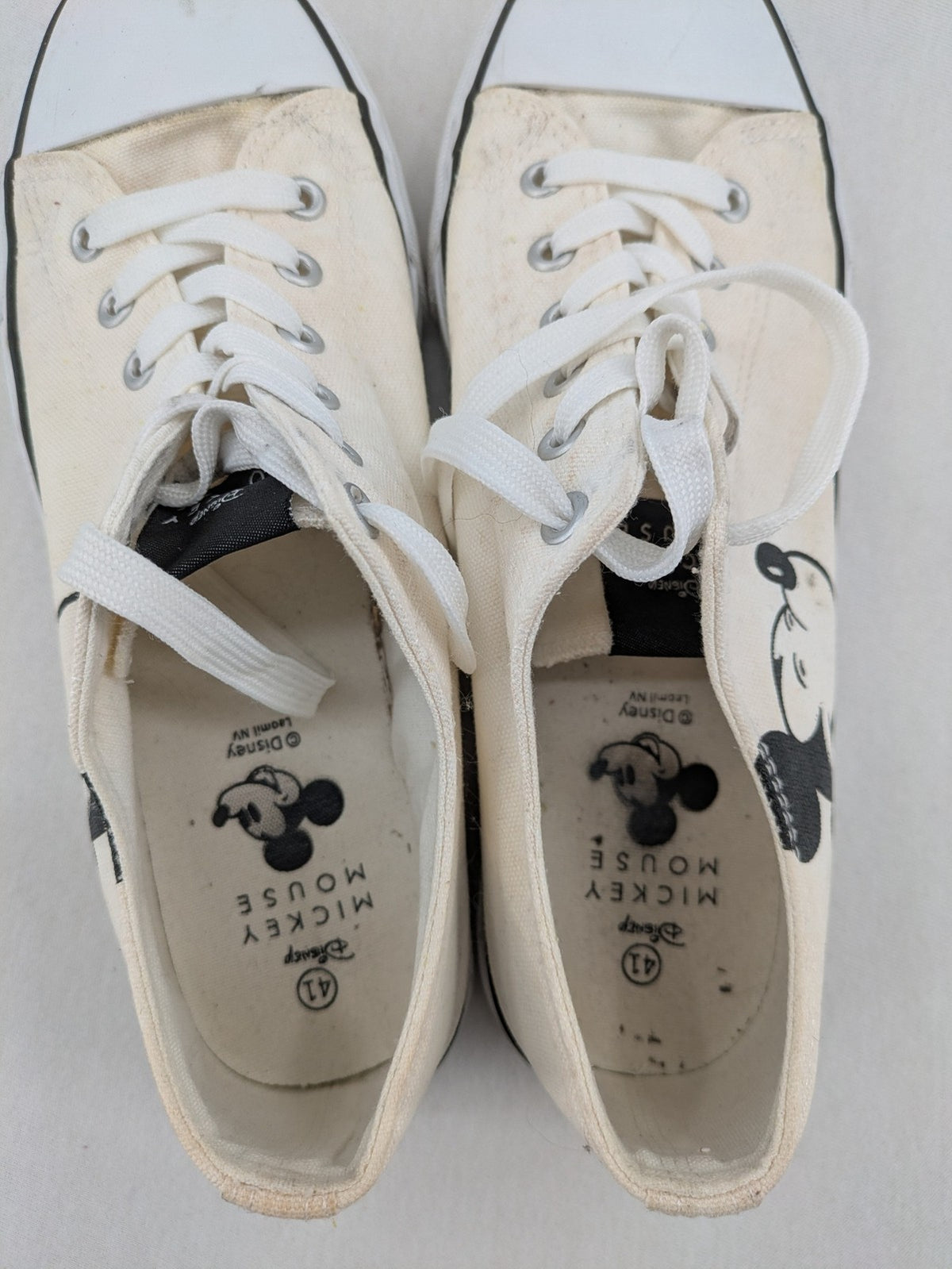 Disney Mickey Mouse white canvas low top sneakers with iconic Mickey Mouse graphic.