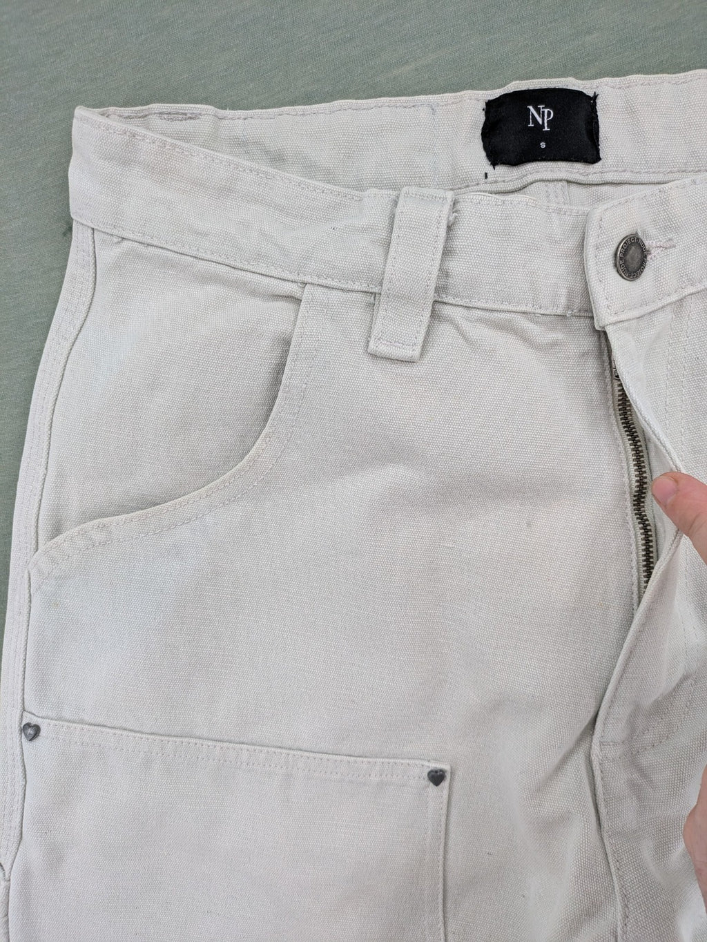 NUDE beige pants with double knee reinforcements and multiple utility pockets.