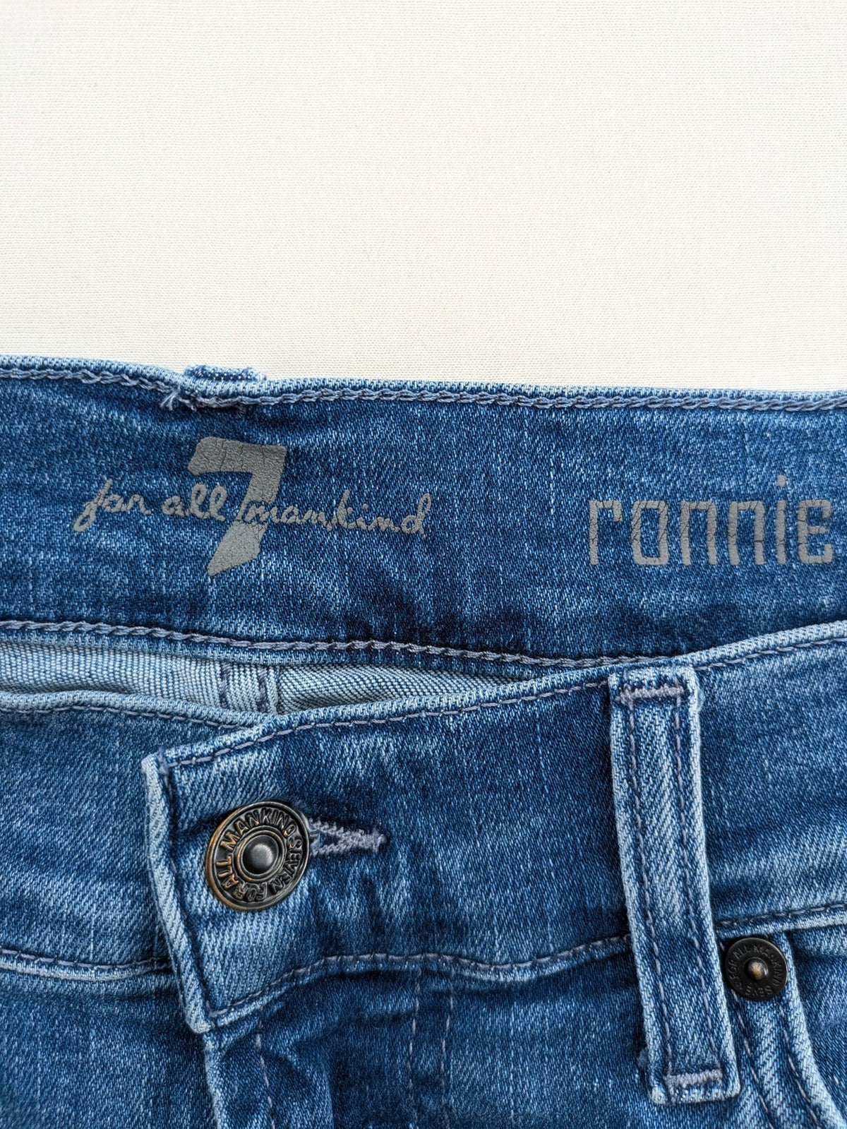 7 For All Mankind blue straight jeans with 5-pocket design and logo on back pocket.