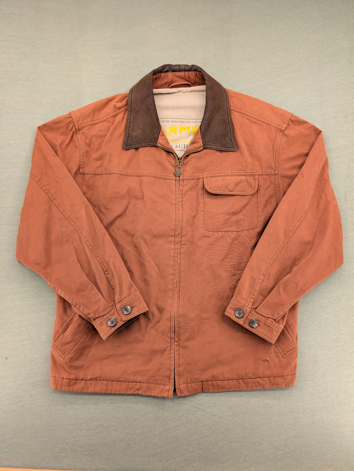 Camel Collection brown jacket with orange contrast collar and embroidered logo.