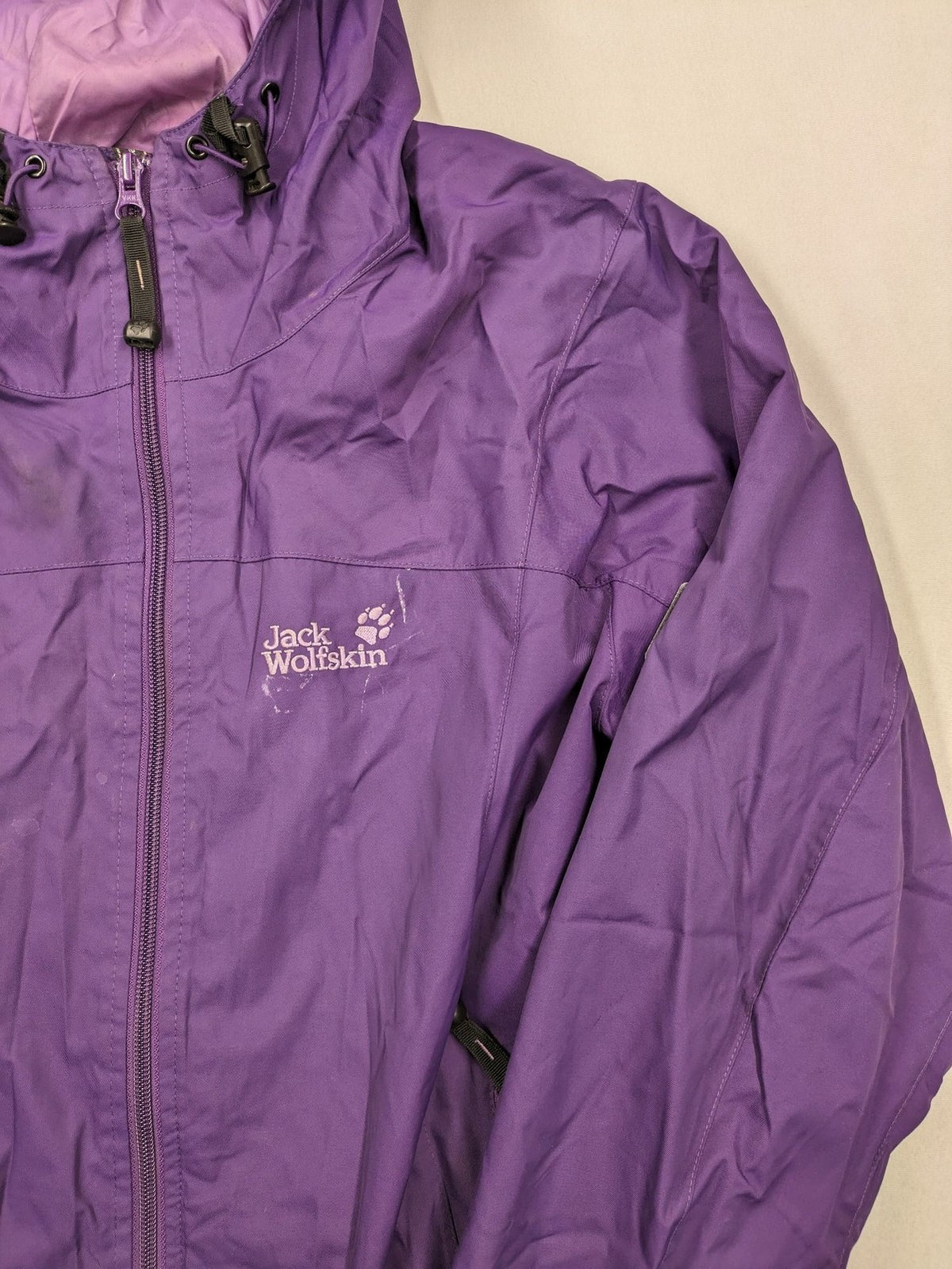 Jack Wolfskin purple outdoor jacket with adjustable hood and full zip, lightweight Stormlock material.