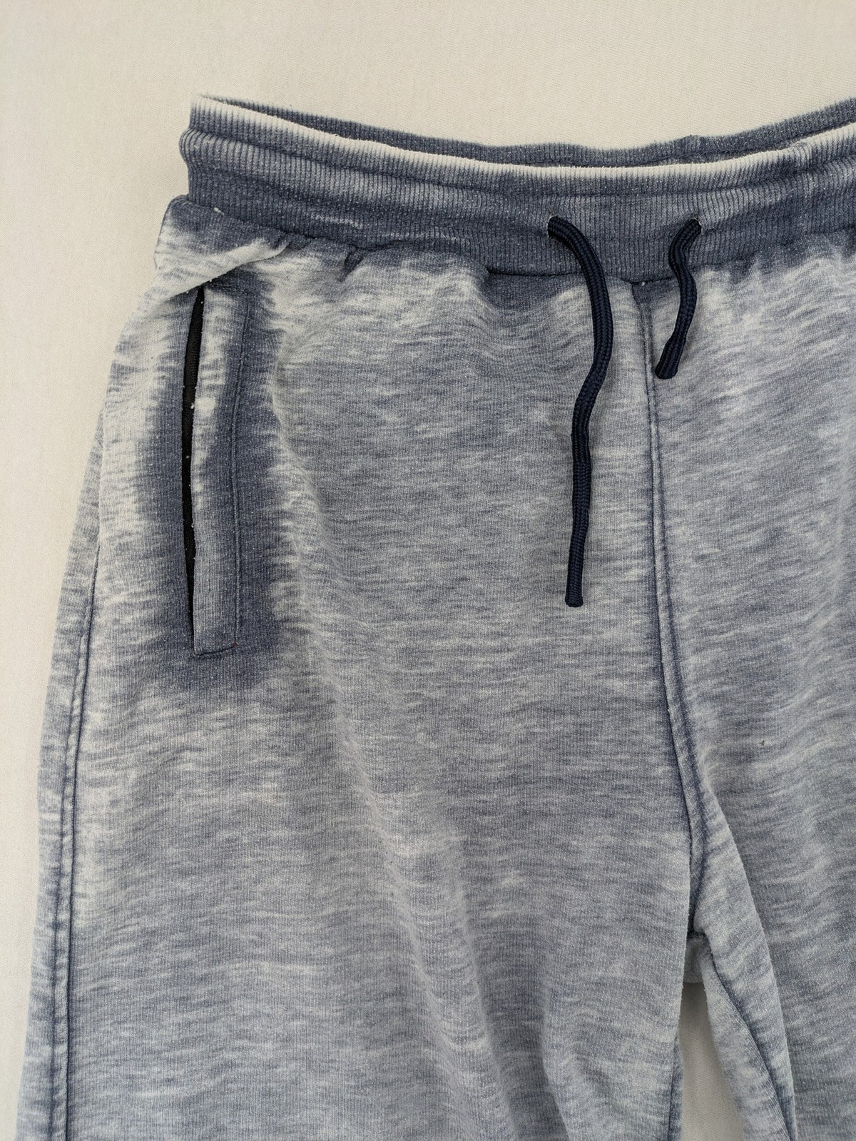 Nike grey acid wash jogger shorts with embossed logo and zip pockets.