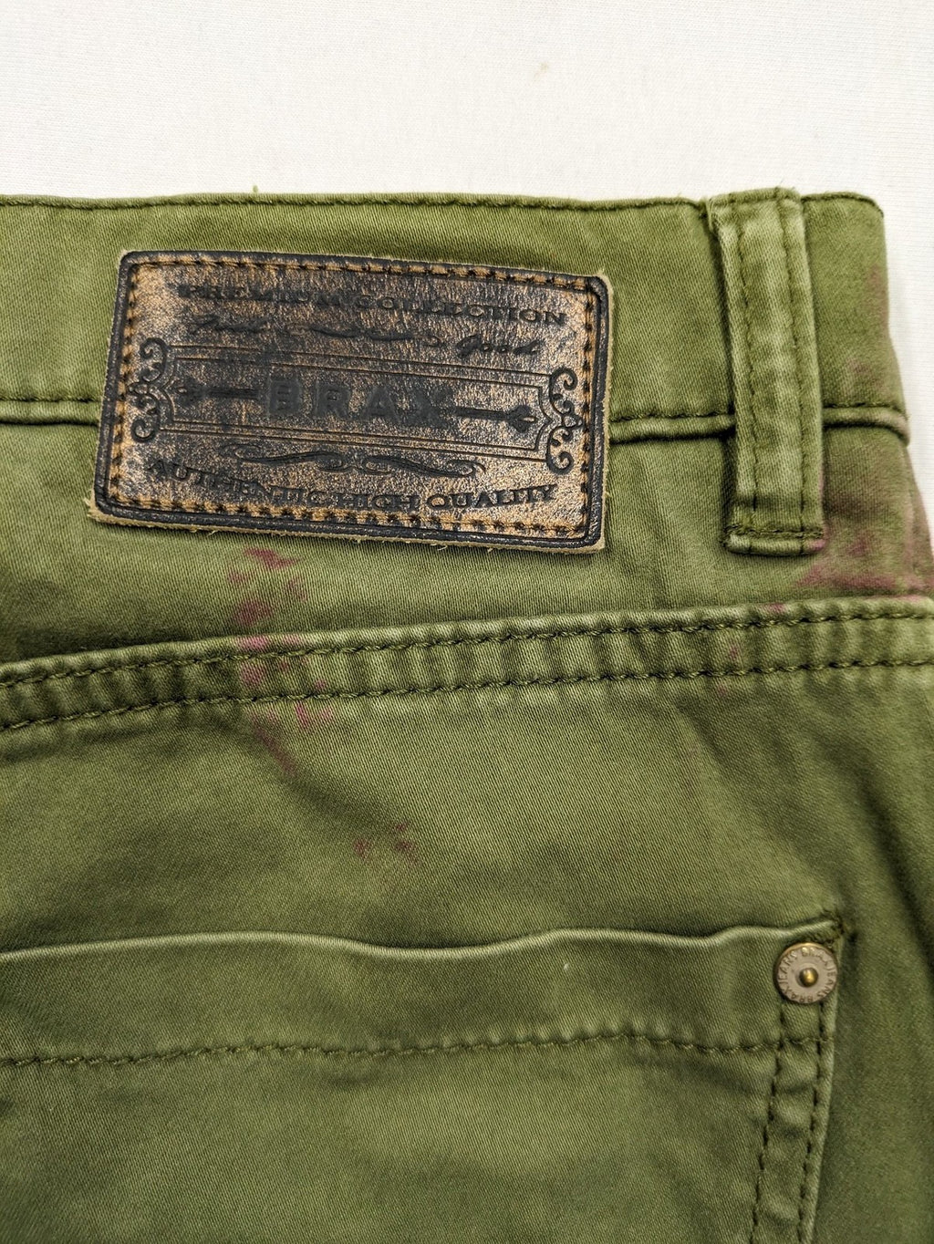 BRAX khaki pants classic five-pocket style with logo patch and zip button closure.